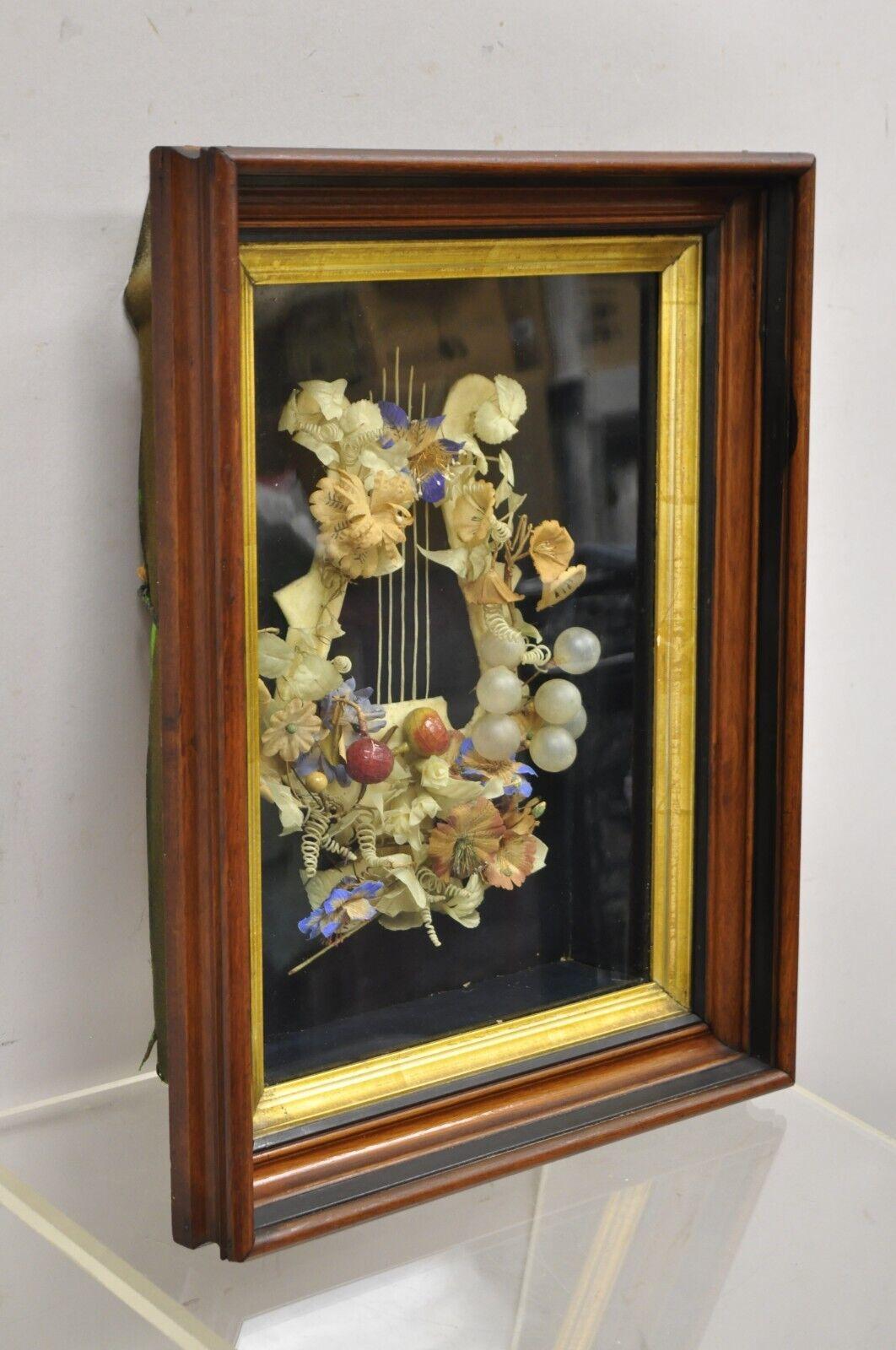 Cadre ancien victorien en acajou avec couronne de deuil en forme de harpe. L'objet présente un motif de harpe, une couronne de fleurs, un cadre en acajou profond, une bordure dorée, un très bel objet ancien. Circa  19ème siècle.
Dimensions : 17,5