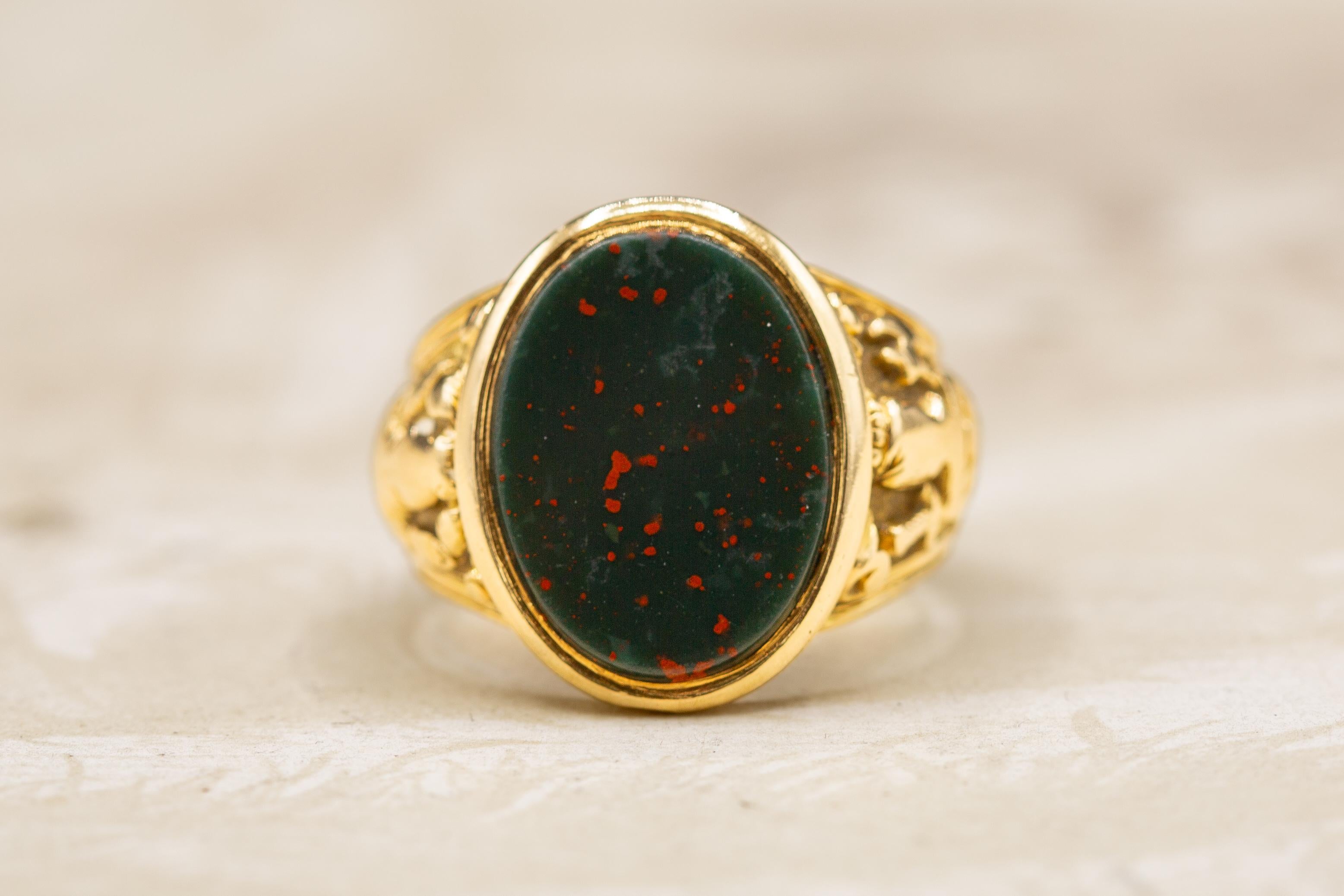 A superb and heavy solid 18K gold antique signet ring, made in 19th century Victorian England, circa 1890. 

The centrepiece of this substantial gold ring is an oval bloodstone gemstone with excellent colouration and evenly spread bright red
