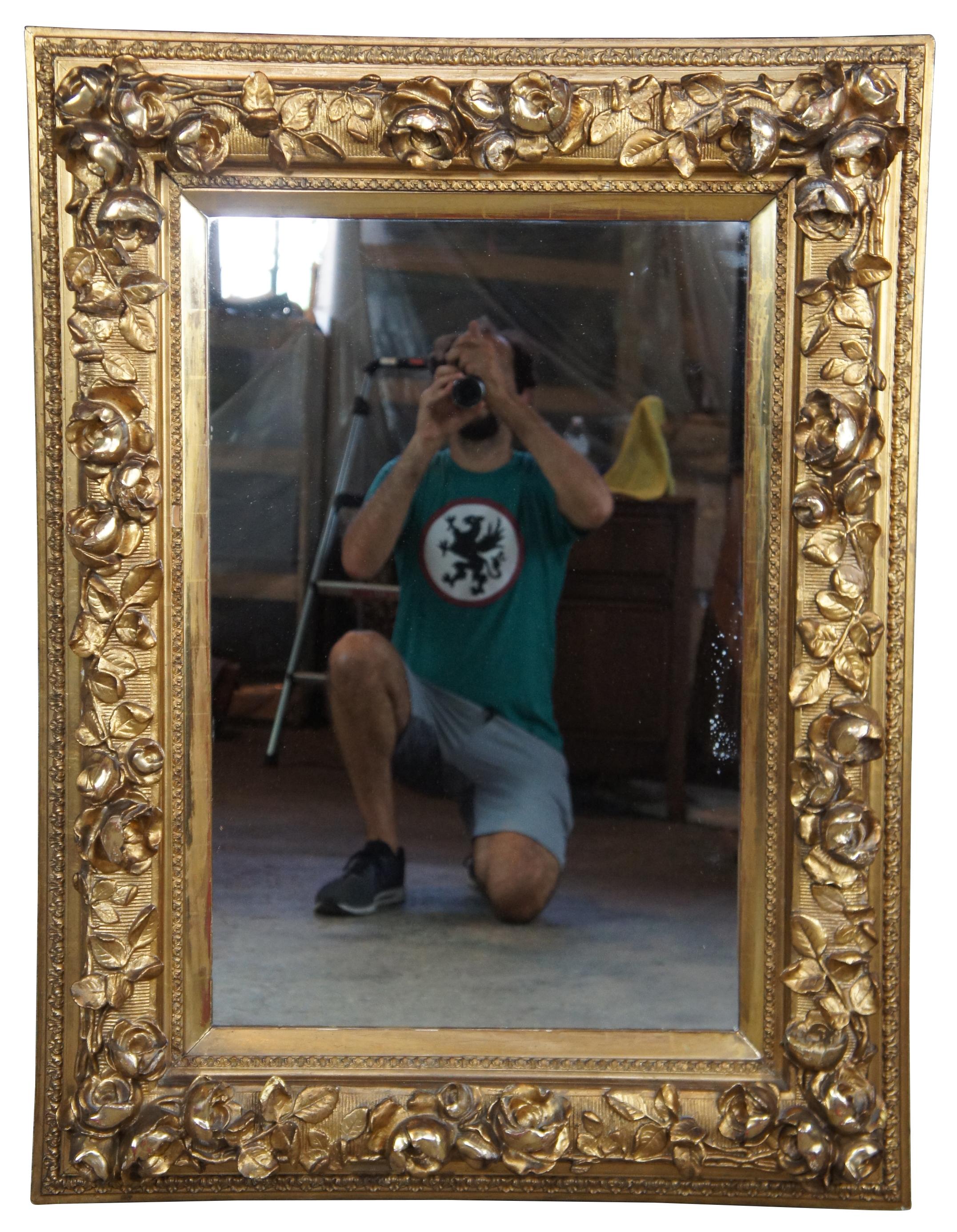 19th century high relief gold mirror. Made from pine with an elaborate rose vine design along the frame. Features gadrooning along the trim and a mirror that could be replaced with artwork if desired. Measures: 44”.
   
