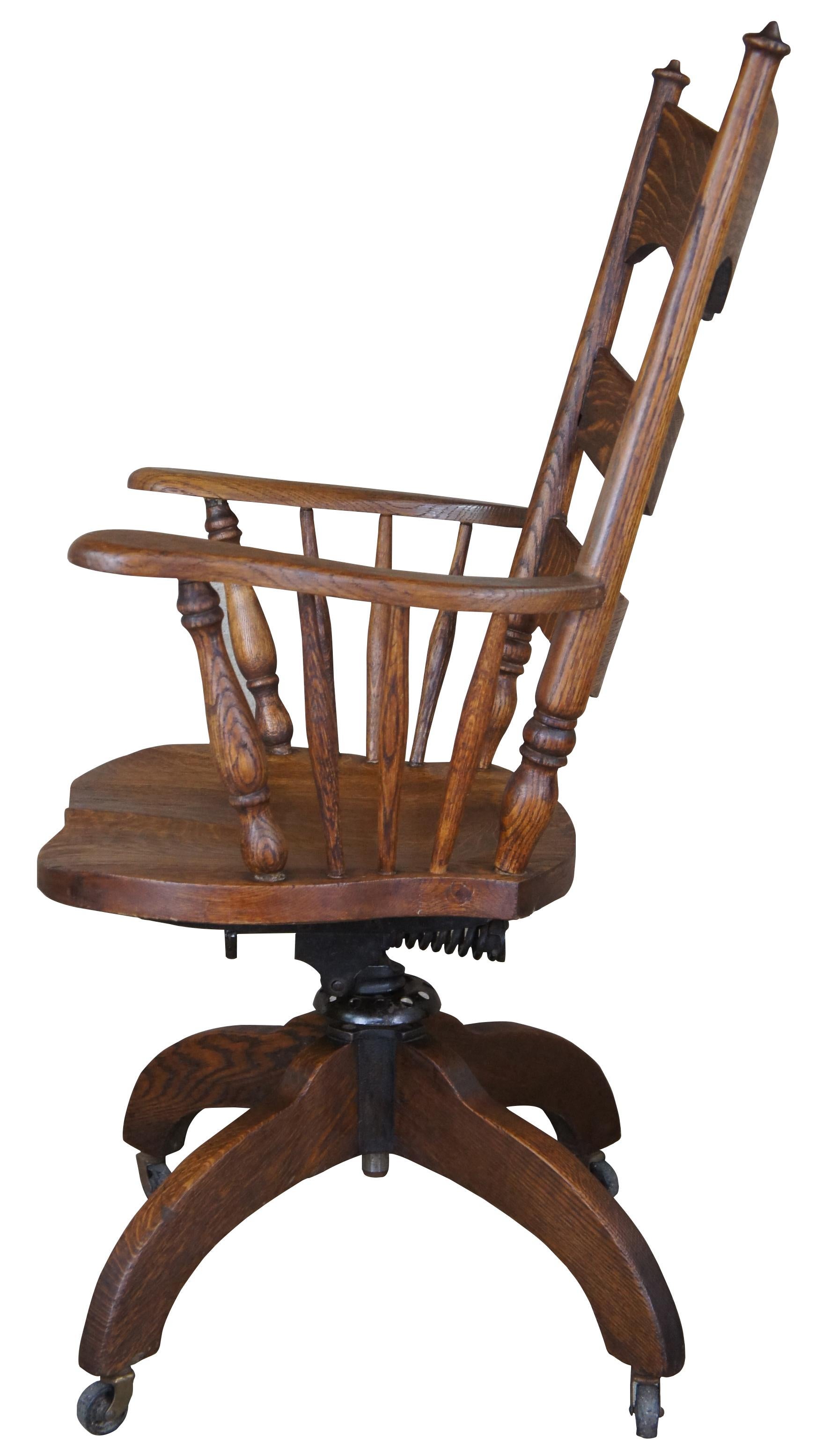 Early 1900s Hubbard, Eldredge & Miller office or desk chair. Made from quartersawn oak featuring a ladder back design with an engraved slat, finials and flared arms. The chair sits upon an adjustable base with tilt function. Hubbard, Eldredge &