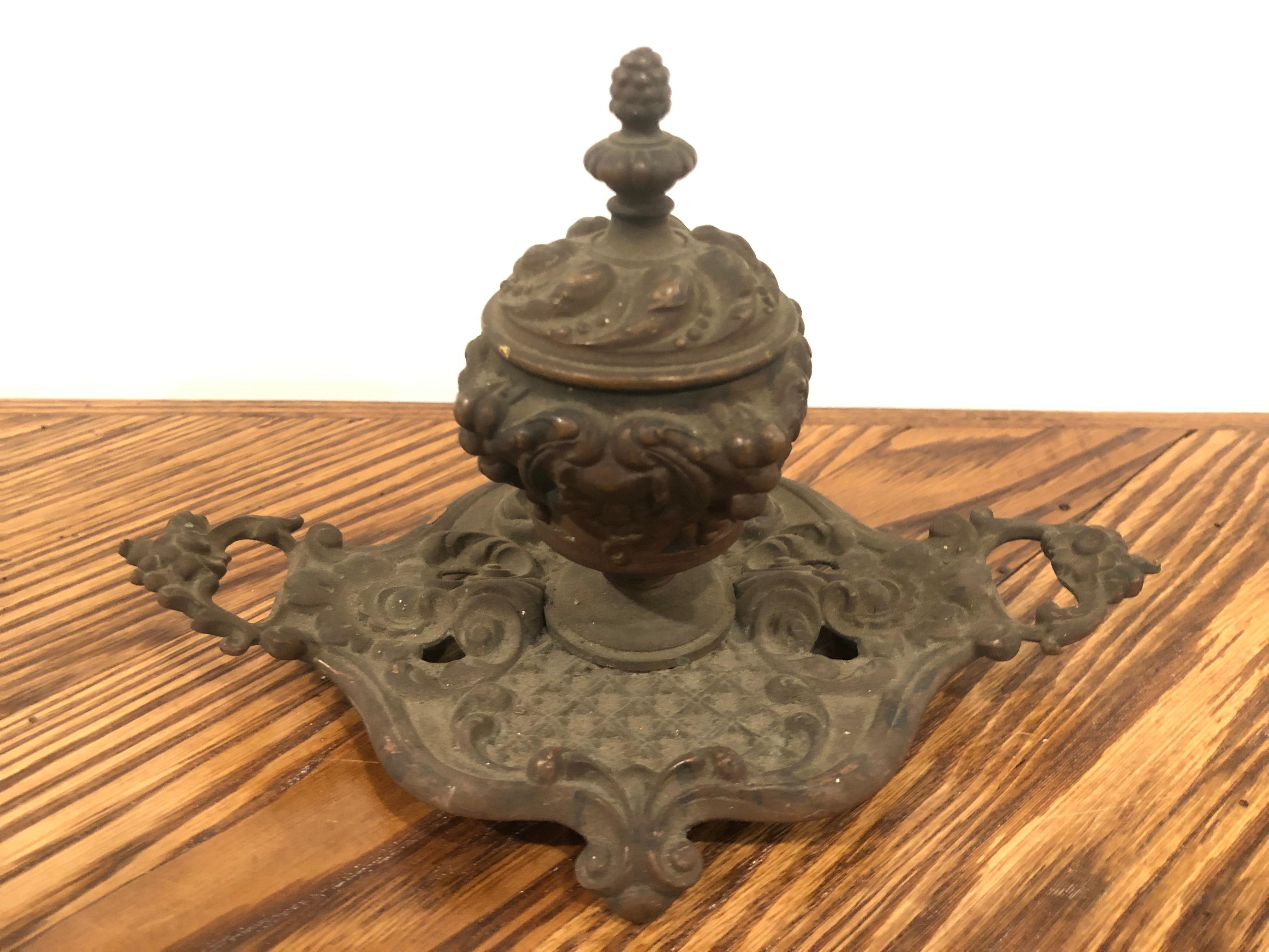 Decorative Victorian brass inkwell with a glass insert a nice size and good conversation piece for any desk. This inkwell could use a good cleaning or polishing but I think it looks great in its original condition.