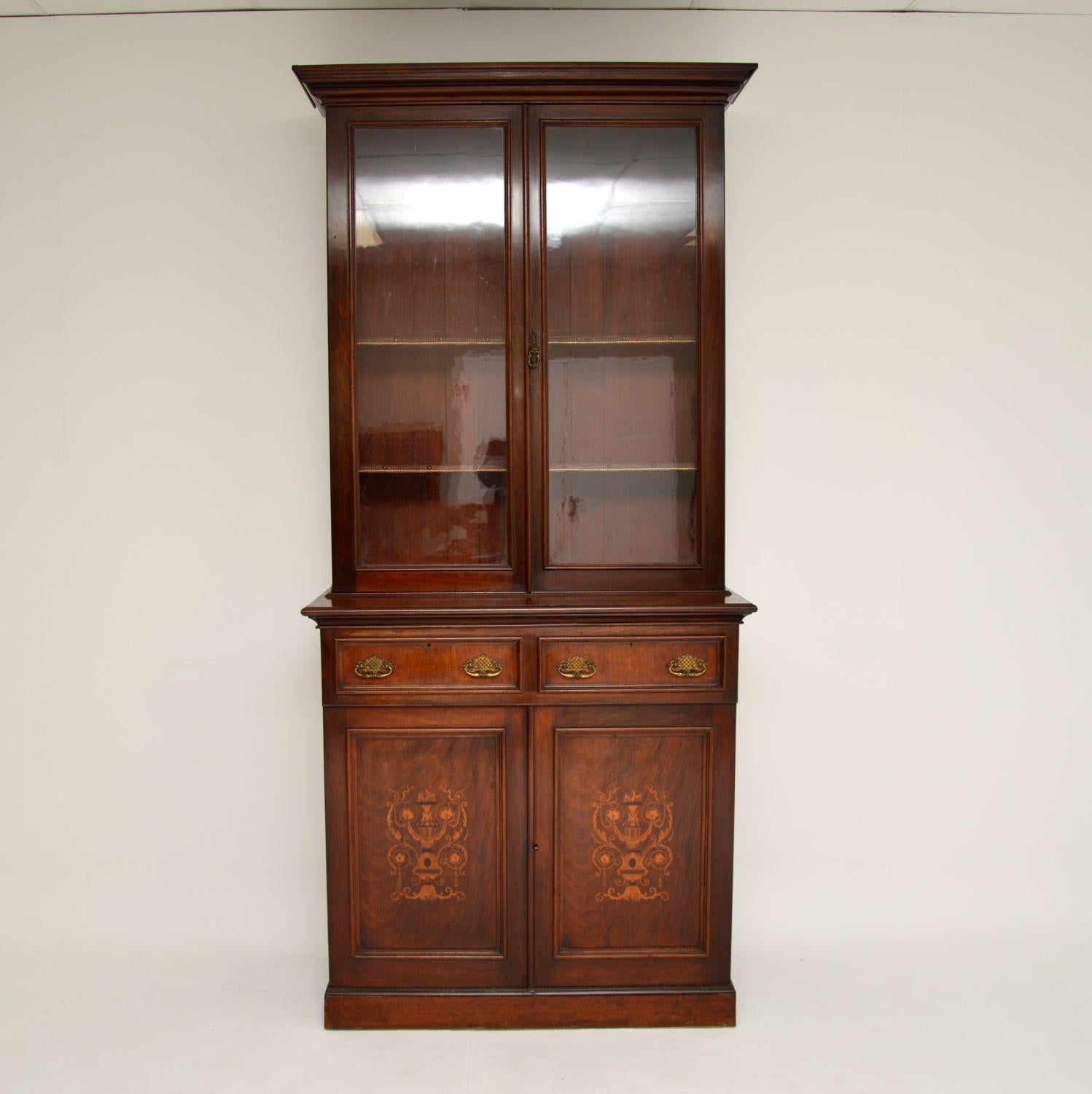 A very impressive antique bookcase, beautifully made from wood with satin wood Marquetry of classical design on the lower door panels. This dates from circa 1860s-1880s period.

It’s quite tall, and is of amazing quality. The upper cabinet has three