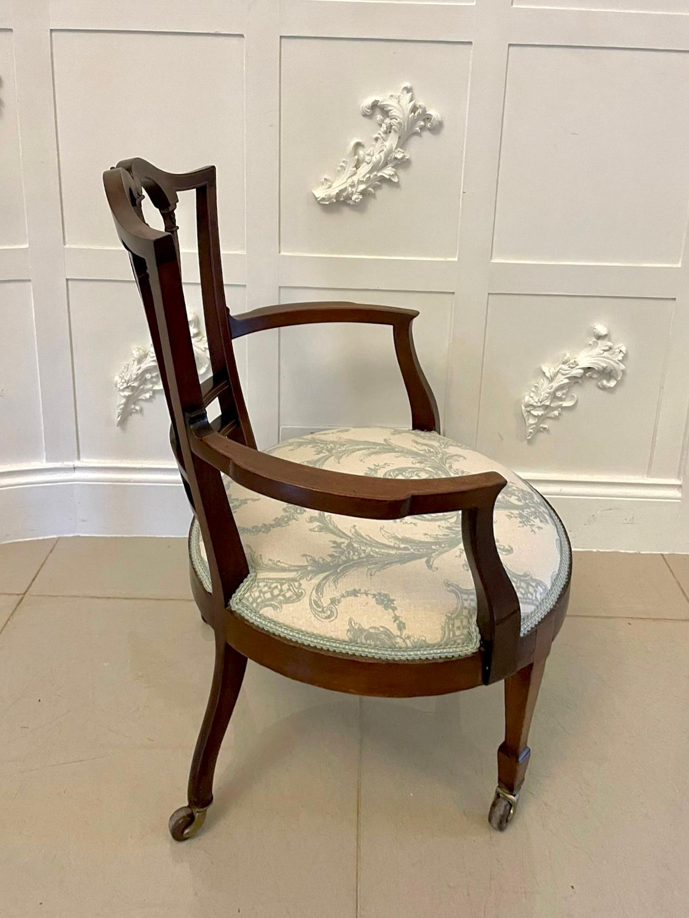 Antique Victorian inlaid mahogany armchair having a pretty inlaid shaped back and centre splat, shaped arms, standing on elegant inlaid square tapering legs with spade feet to the front and shaped back legs with original castors

A quaint chair