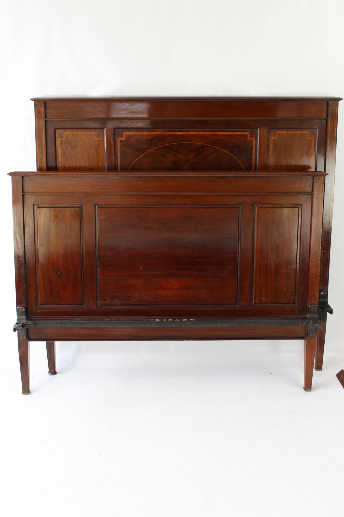 A good quality antique late Victorian mahogany and inlaid double bed dating from circa 1900. In a richly figured mahogany frame, with panelled headboard and footboard inlaid with satinwood. Featuring flame figured mahogany veneers to the central