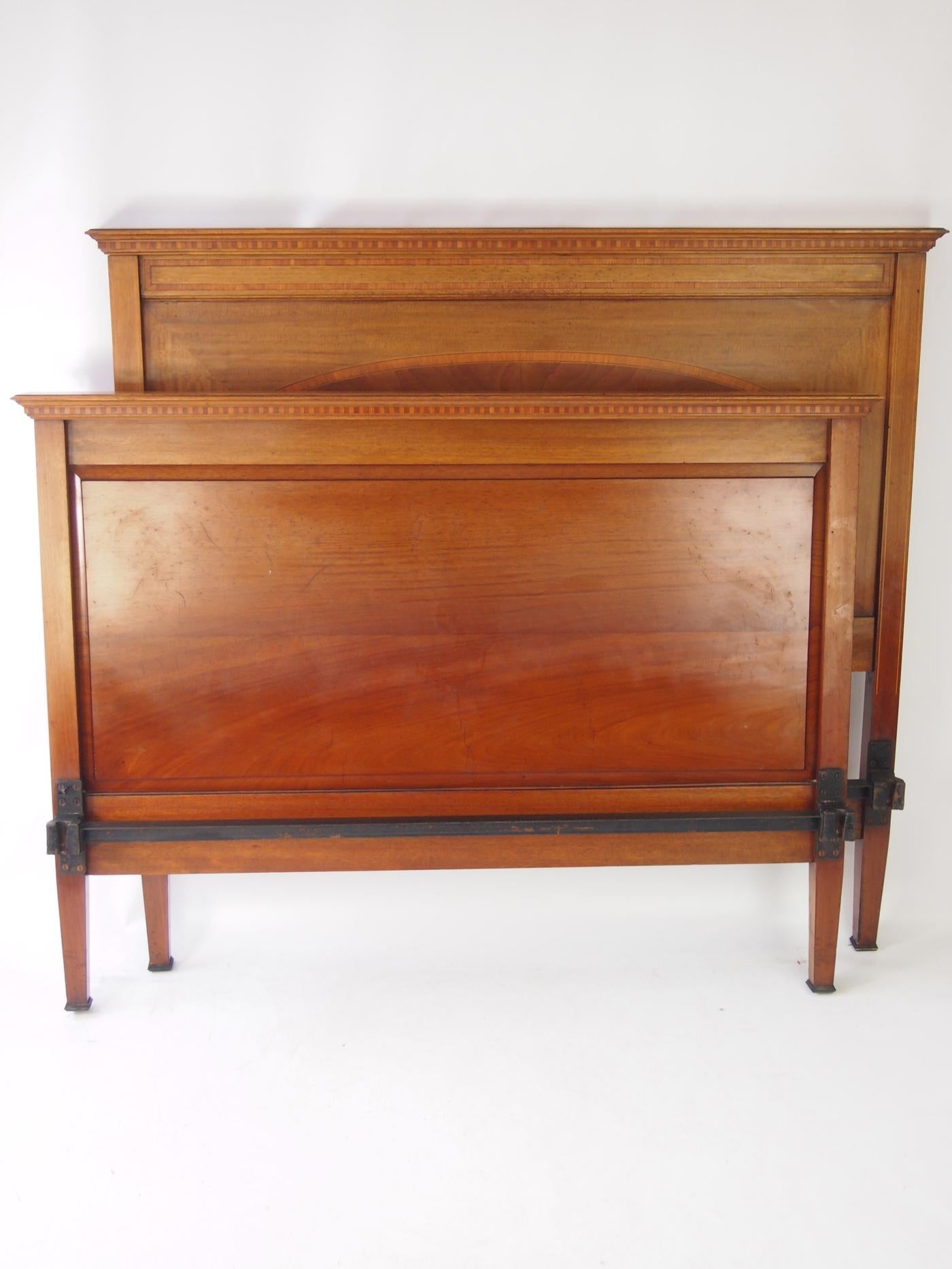 A handsome antique late Victorian mahogany and inlaid double bed dating from circa 1895. In a richly figured mahogany frame, the headboard and footboard inlaid with satinwood. Featuring oval shaped flame figured mahogany veneers to the footboard and