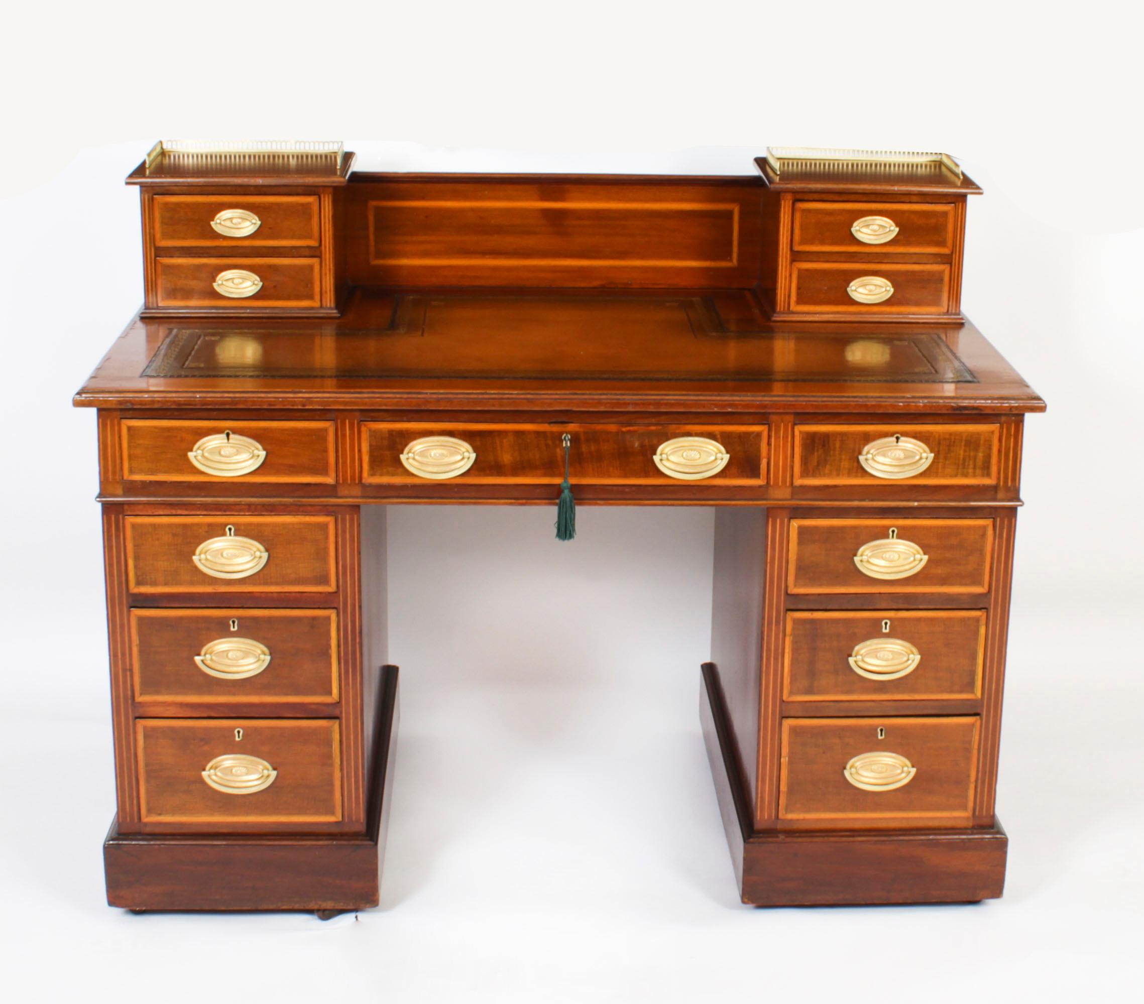 This is a superb antique Late Victorian Flame mahogany string inlaid and satinwood crossbanded pedestal kneehole desk, circa 1880 in date.

It is made from fabulous flame mahogany, the rectangular top with an inset shaped olive green and tan  gold