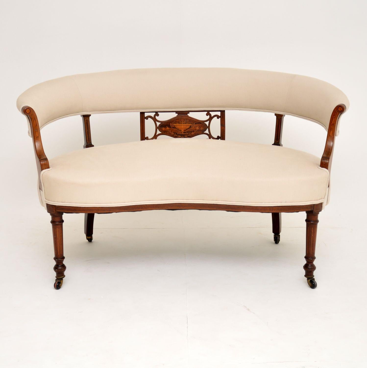 This antique Victorian upholstery settee has a curved back & a kidney shaped front edge. It dates from circa 1890 period & is in excellent condition, having just been re-polished & re-upholstered in our regular cream natural cotton linen