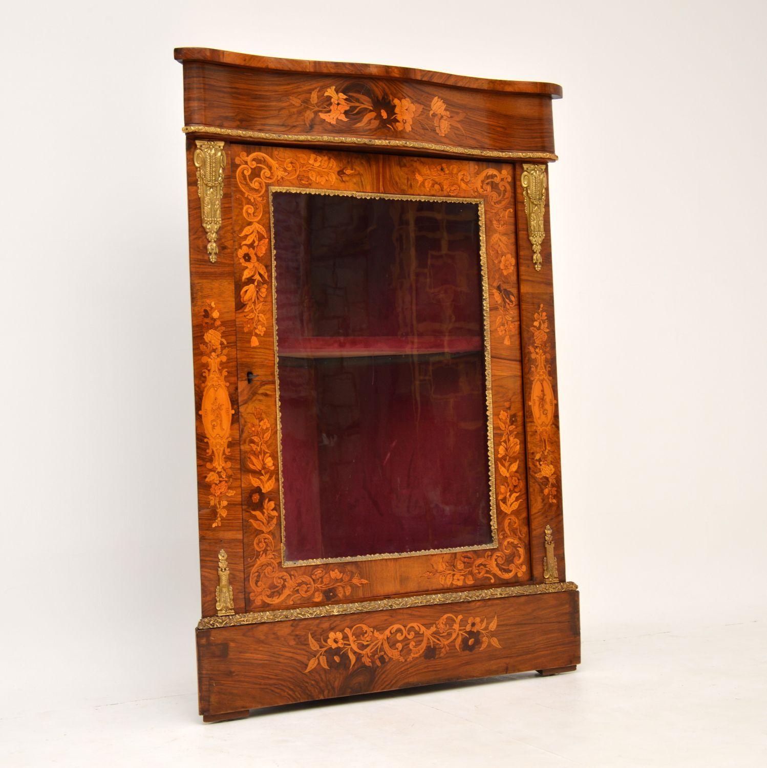 Antique Victorian figured walnut corner cabinet with wonderfully detailed floral marquetry all-over & other inlays. It has a serpentine shaped top & gilt bronze mounts on the top & bottom of the sides. There are also gilt metal trimmings, top &