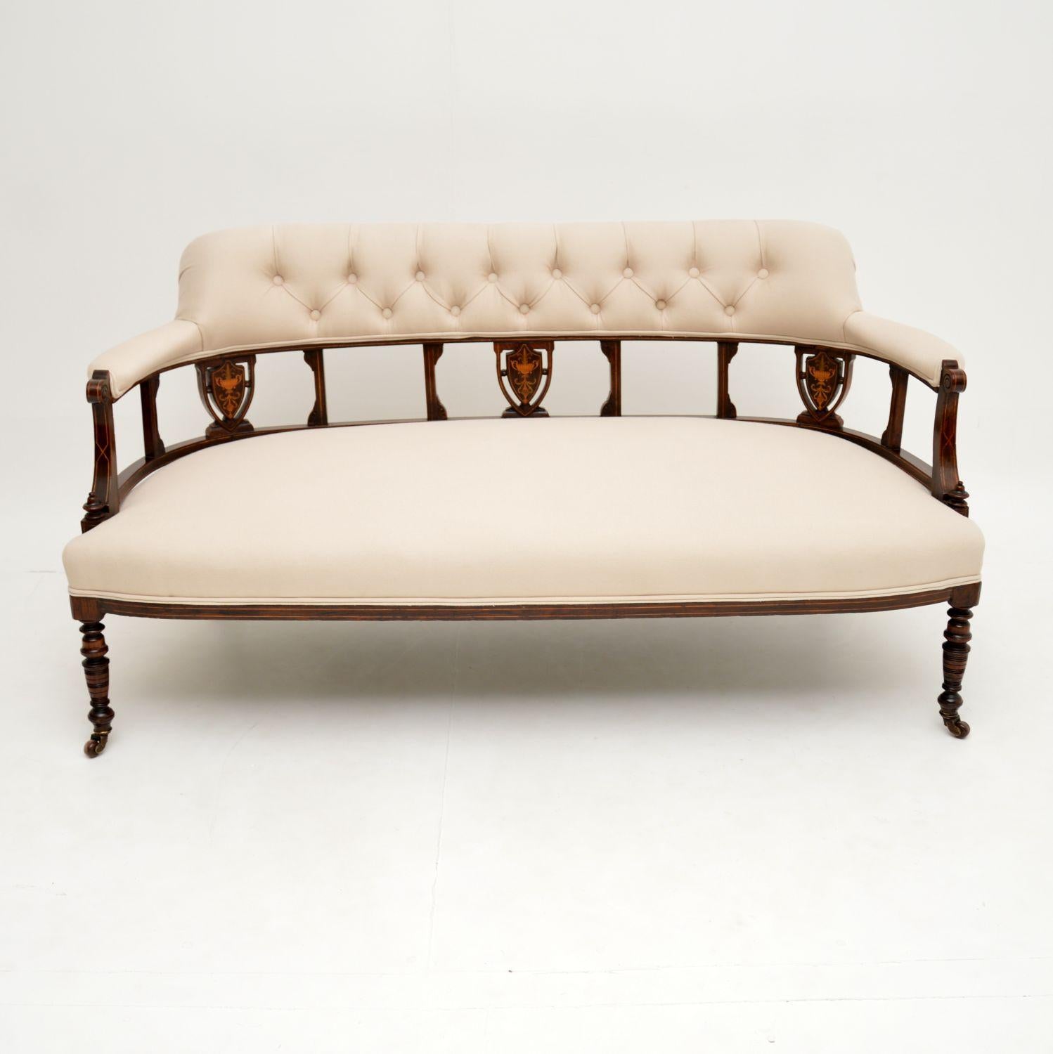 A stunning antique settee dating from the 1890-1900 period. This is finely made from solid wood, with beautiful satin wood inlays.
It is well built, sturdy and sound, it sits on beautifully turned legs terminating in original porcelain