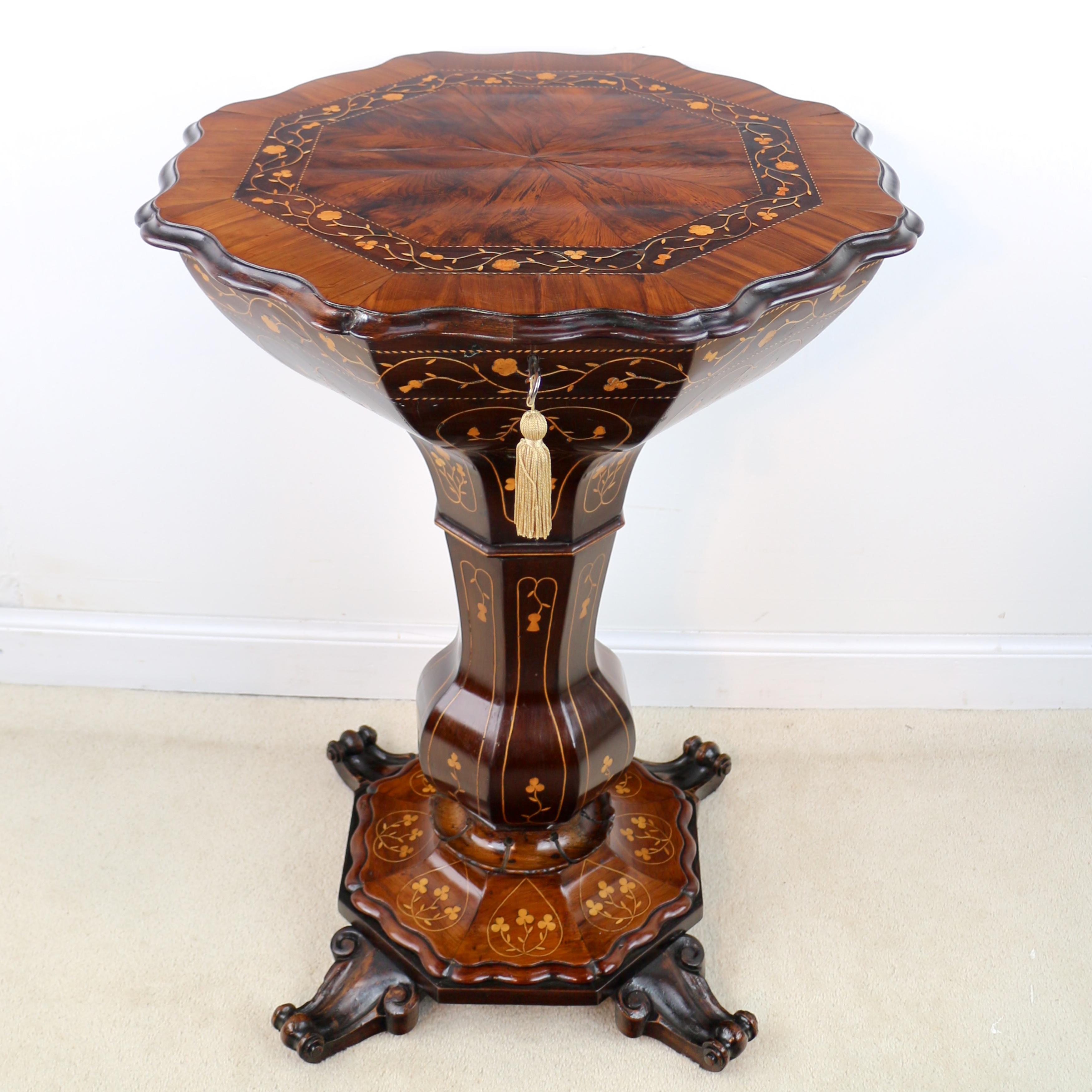 An exceptional quality Irish Killarney ware arbutus work table inlaid throughout with shamrocks, thistles and roses. The shaped octagonal top with radial veneers and opening to reveal a removable sectioned and lidding sewing tray with paper lined