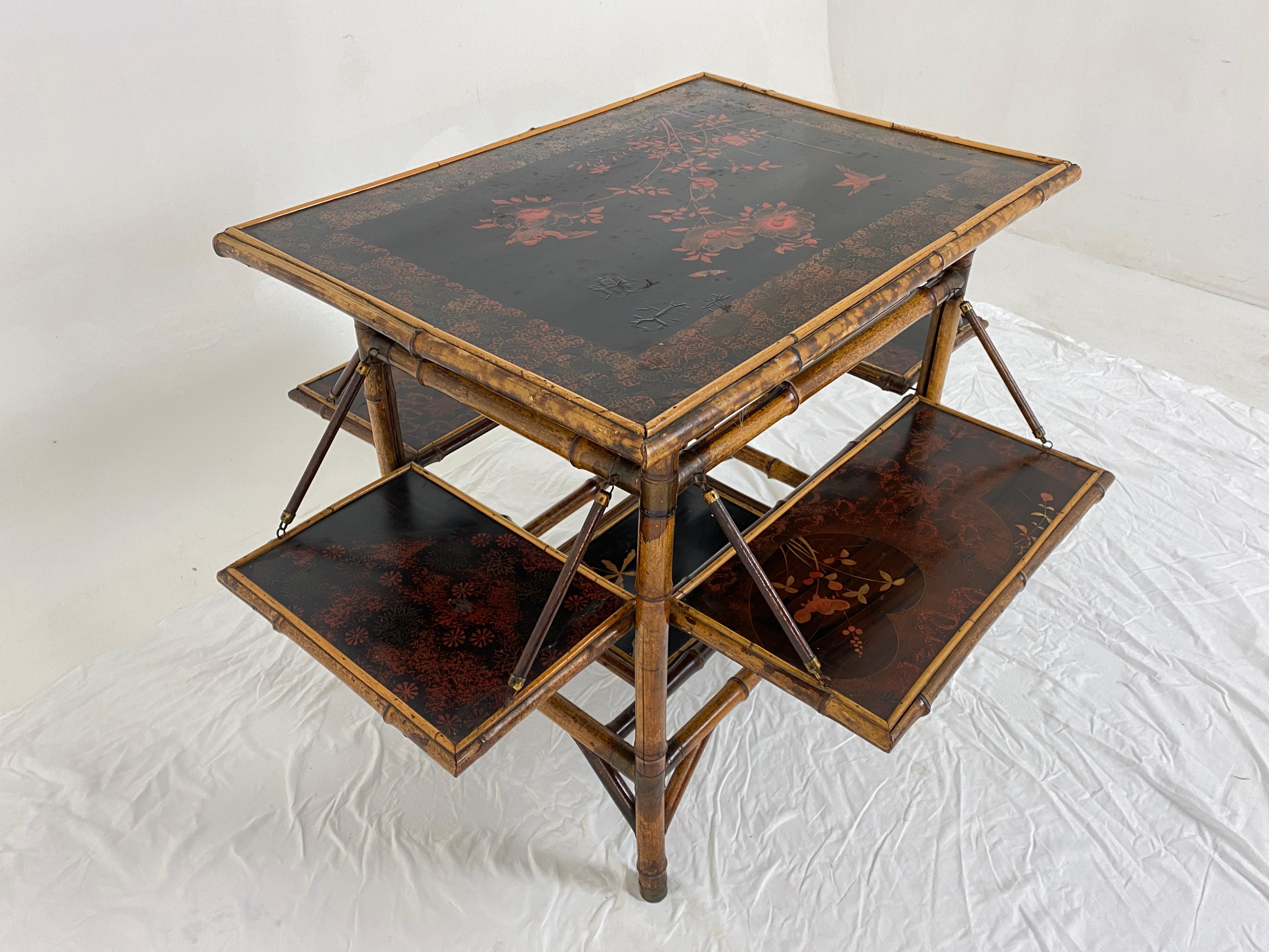 Antique Victorian Japanned tiered bamboo table Chinoiserie, Scotland 1880, H735.

Scotland 1880
Bamboo
Original Finish
Rectangular Top with lacquered chinoiserie panel in the oriental style with blossoms, foliage and buds.
Four folding shelves with