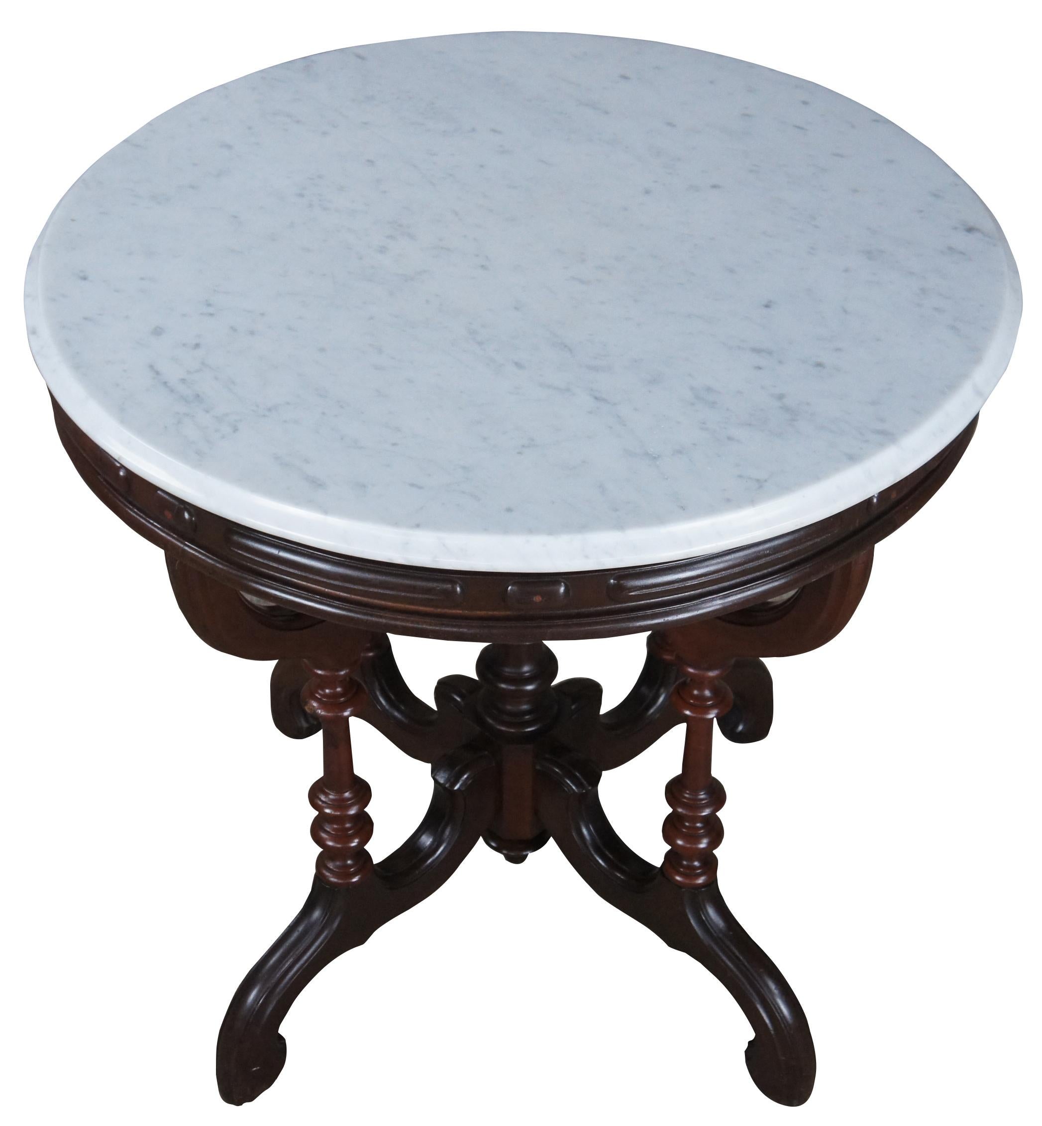 Antique Victorian parlor center table from J.H. Crane of Saint Louis Mo. Made of walnut featuring round form with white marble top and serpentine shaped base with turned posts. Size: 30