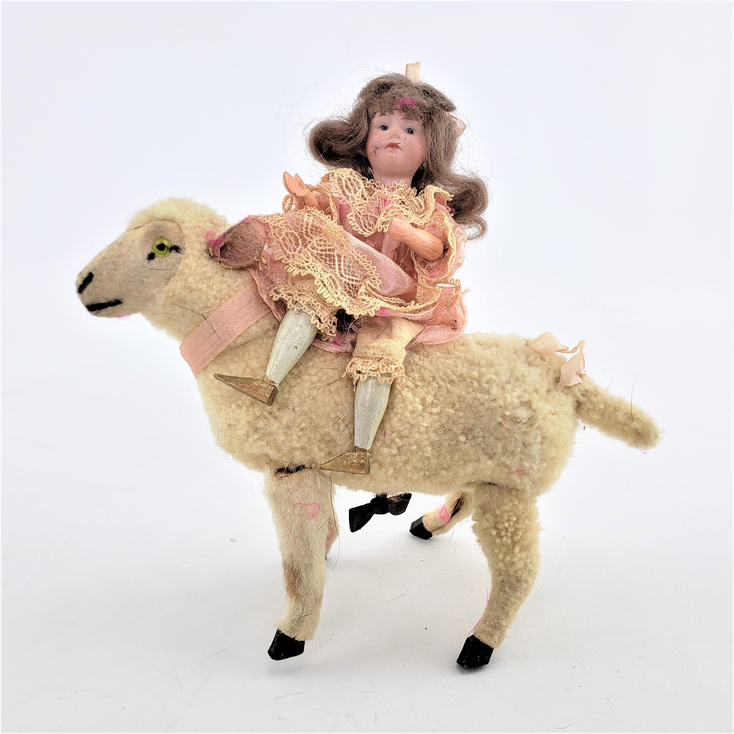 This antique mechanical toy is unsigned, but presumed to have been made in Europe, possibly England or Austria in approximately 1880 and done in the period Victorian style. The toy features a toy mechanical lamb, with a young girl in formal sild