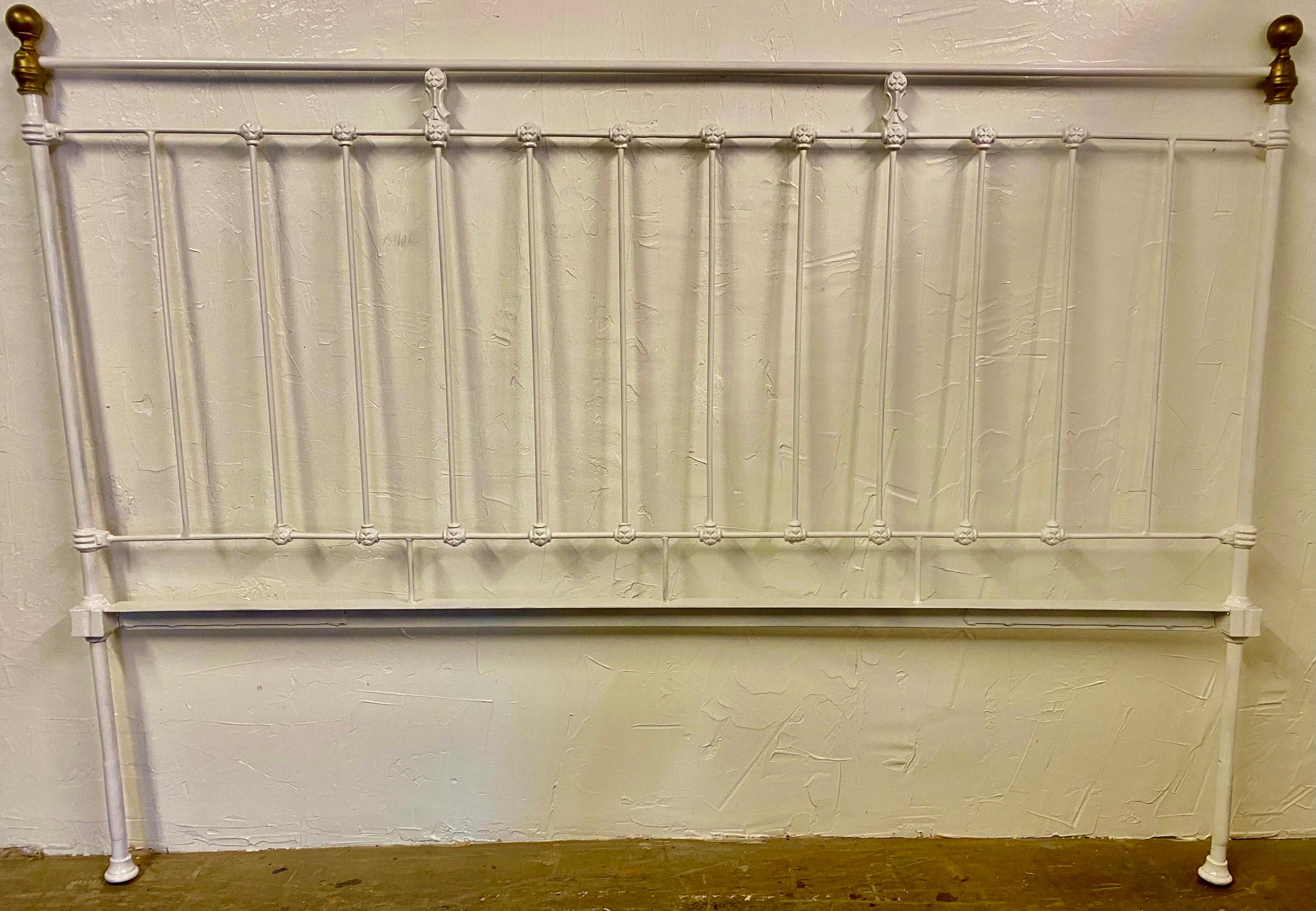 Antique country Victorian style white painted cast iron king size metal headboard with brass finials. Wonderful Classic simple style that will lend itself to modern, classical, neoclassical, Swedish Gustavian or French country decor. 
Search term: