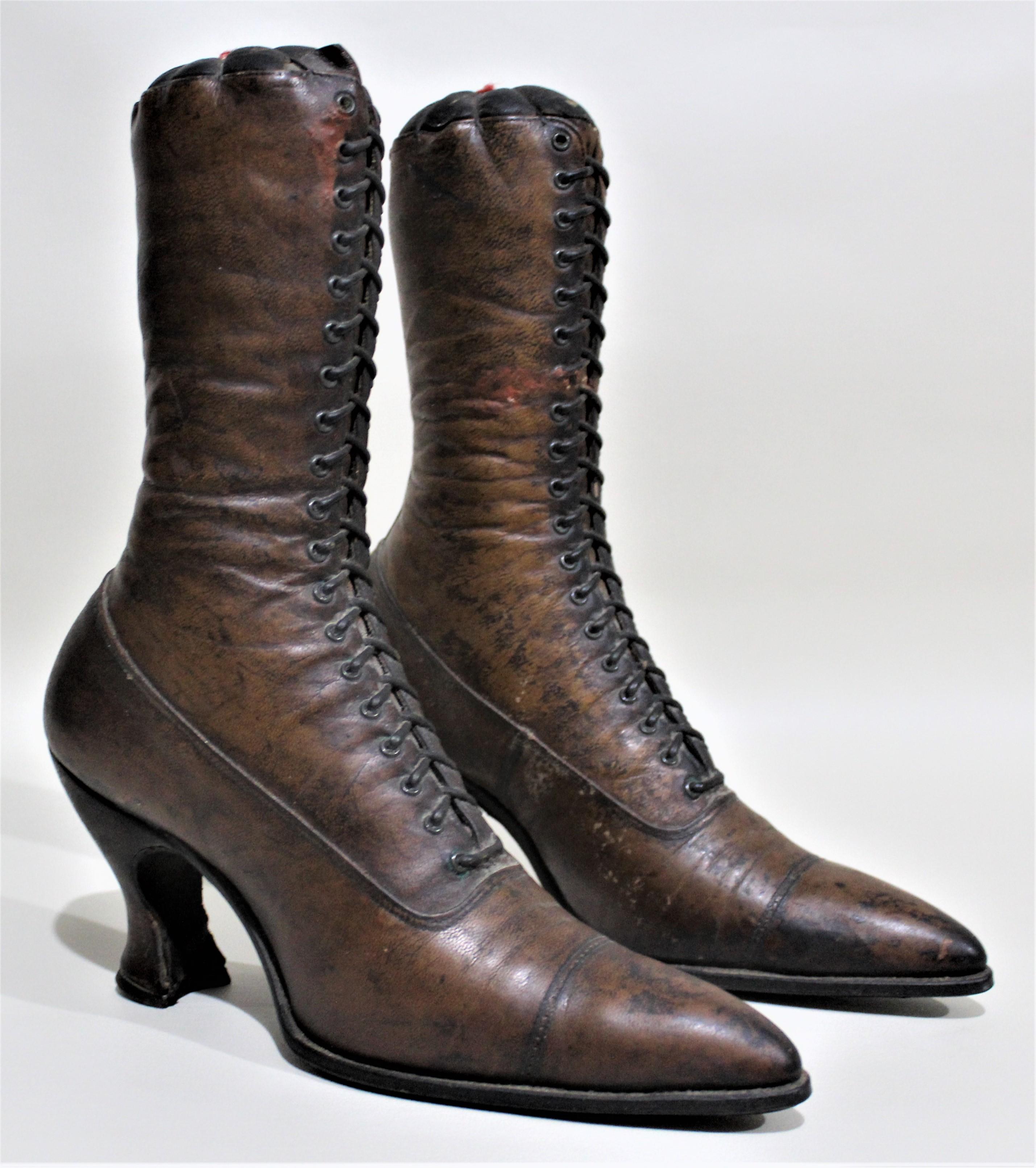 Pair of antique Victorian ladies high boots constructed of brown leather and used as mercantile models for a store display. Each sole has an impressed mark of 