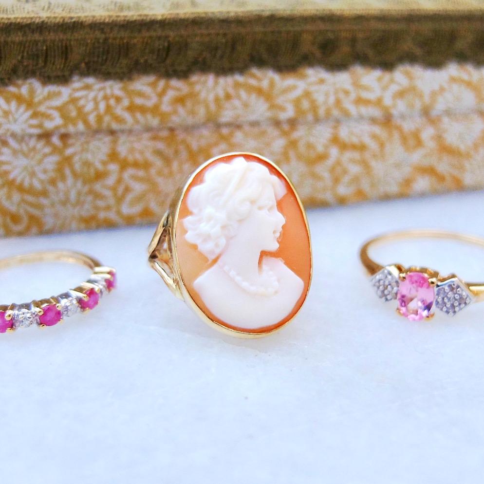 Antique Victorian ring featuring a beautiful carved face from a apricot and white shell. The Lady has a a delicate beaded necklace on. The ring is set in 9ct gold ring.  Cameo jewellery became very popular in the early 19th century cameos features