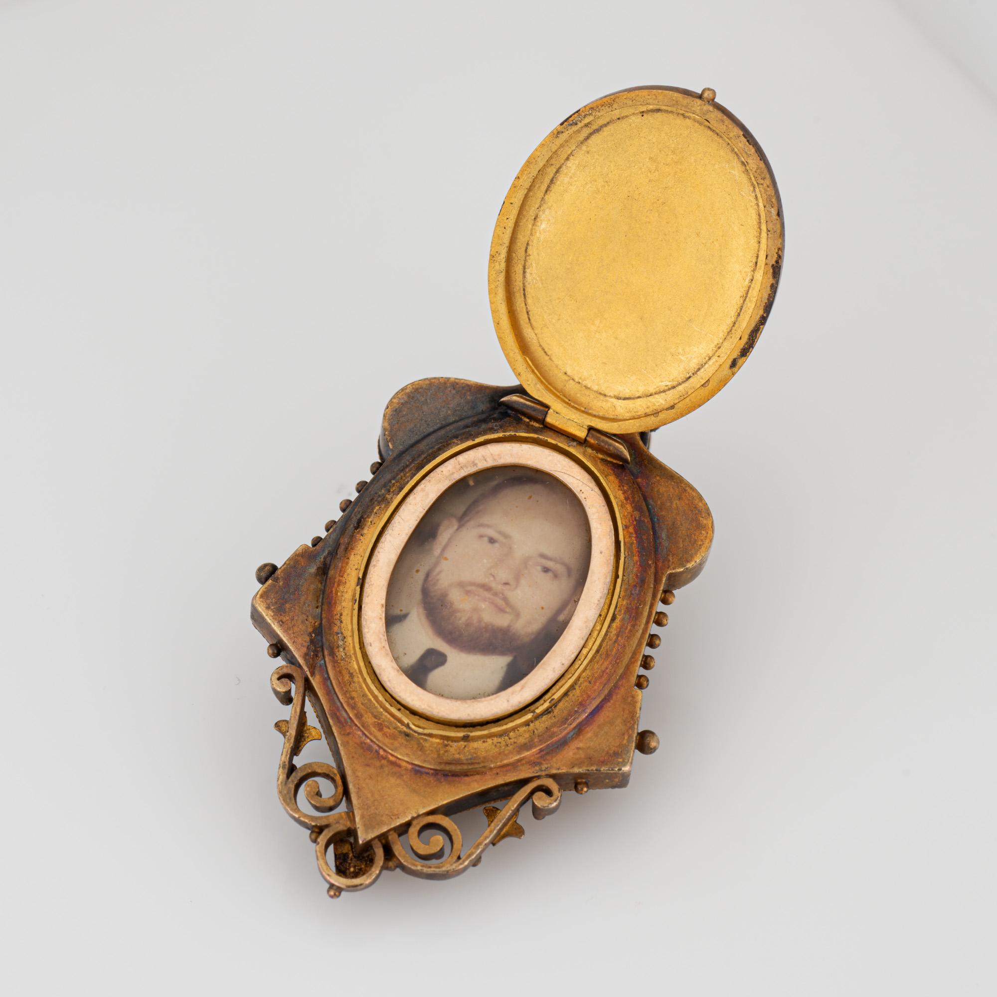 Médaillon victorien ancien (circa 1880-1900) en or jaune 14 carats. 

Deux diamants de taille ancienne totalisent un poids estimé à 0,25 carat (couleur estimée I-J et pureté SI2-I1). 

Ce magnifique médaillon est orné d'un motif élaboré, rehaussé de