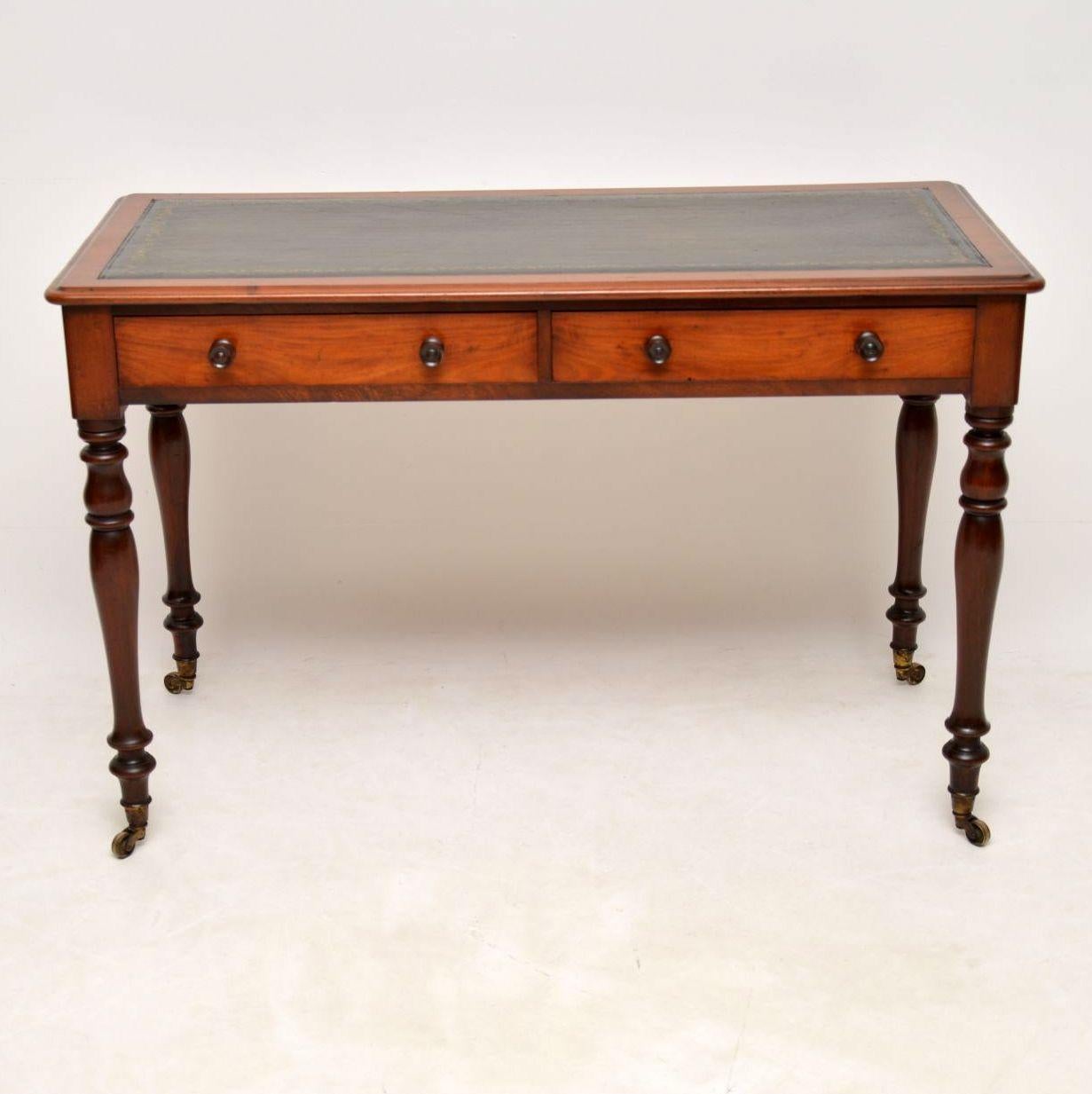 Antique early Victorian mahogany writing table with a tooled leather writing surface & dating to circa 1860s period. It’s superb quality with two drawers on the front & dummy drawers on the back, all with turned mahogany bun handles. The legs are