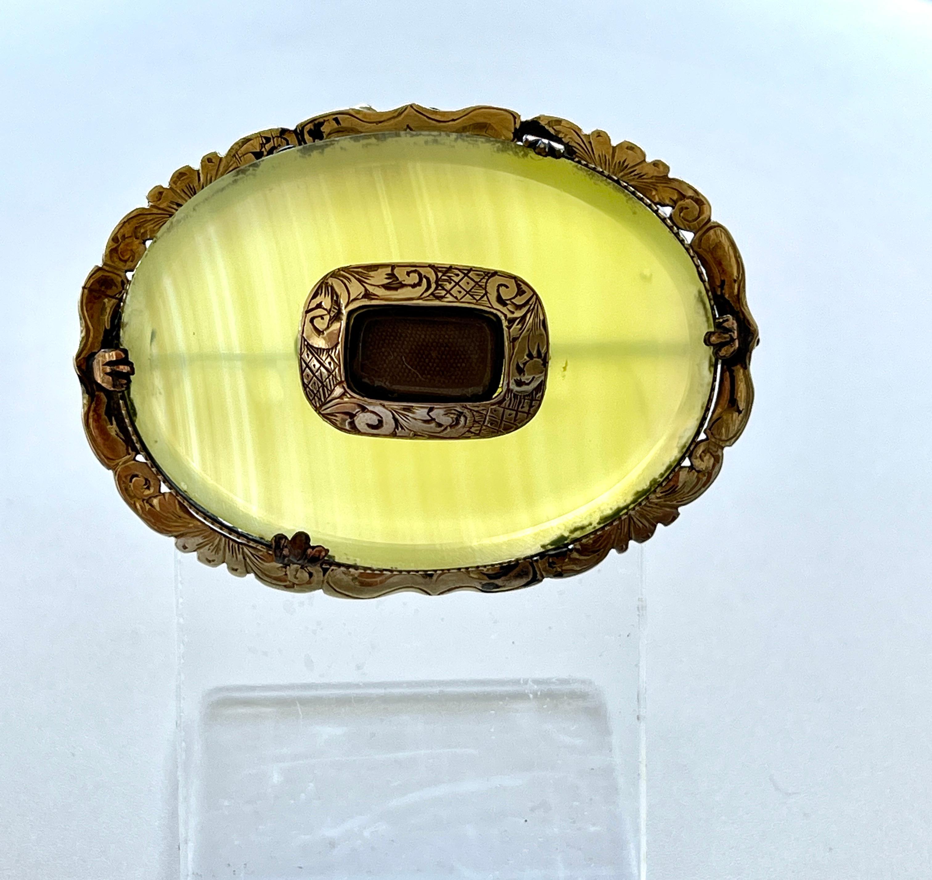 Antique Victorian 9ct Gold Agate Mourning Brooch

This brooch features unusual, lemon coloured, banded Agate which is transparent and very attractive.  
It is set in 9ct yellow gold (acid tested) with scrolling frame work and beautiful, hand