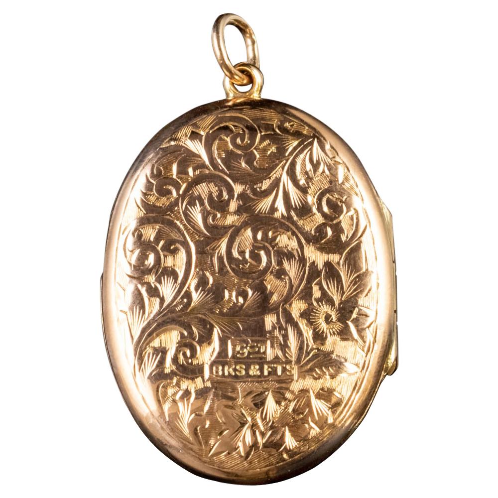 This beautiful Antique Victorian locket has been modelled in 9ct Yellow Gold which has developed a lovely rose hue with age. The front and back feature beautiful and intricate foliate engravings and the front also features the empty form of a shield