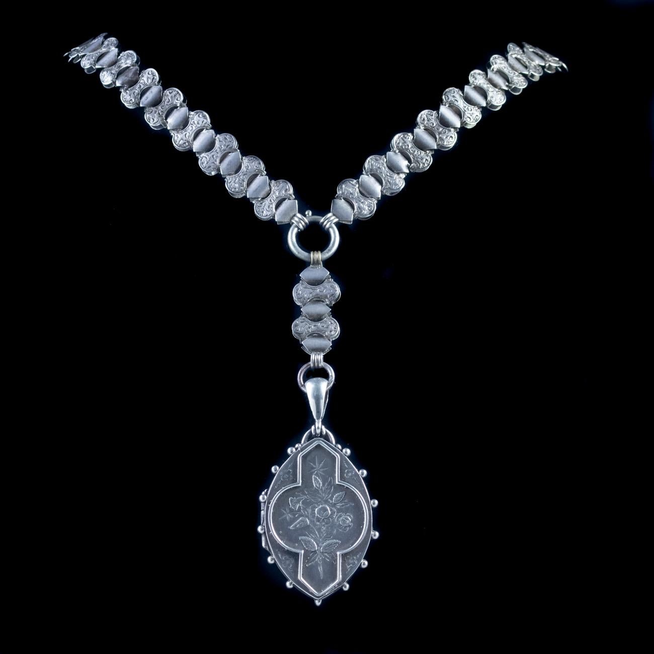 This impressive Antique Victorian locket and collar has been magnificently crafted from solid Silver. The collar features links engraved in a foliate design and is of substantial width. The locket features Forget-Me-Nots engraved on the front and an