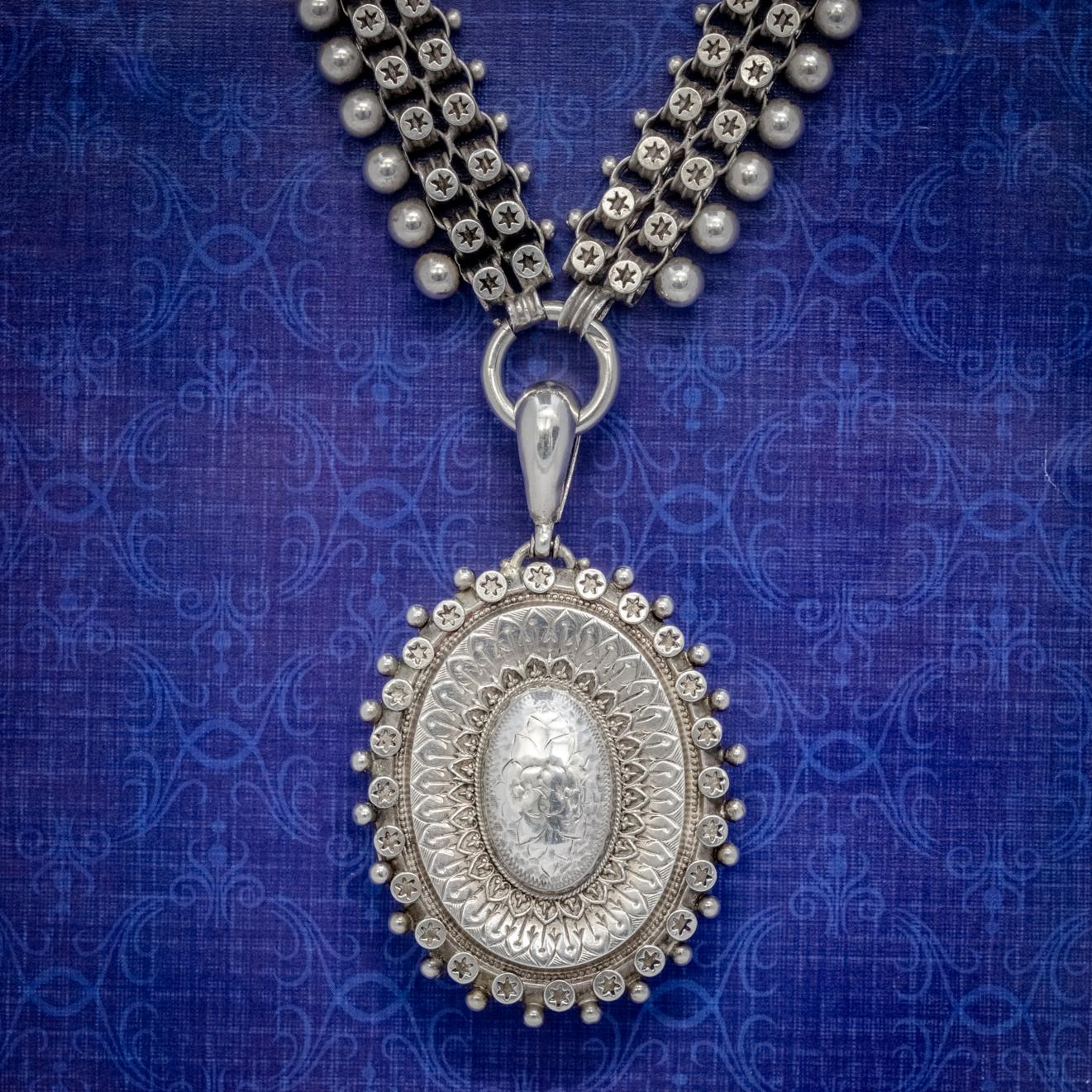 A grand Antique Late-Victorian locket and collar made Circa 1880. The locket is fashioned in Sterling Silver and displays intricate engraved workmanship with Silver balls and stars surrounding the border and lovely etched Forget me nots on the