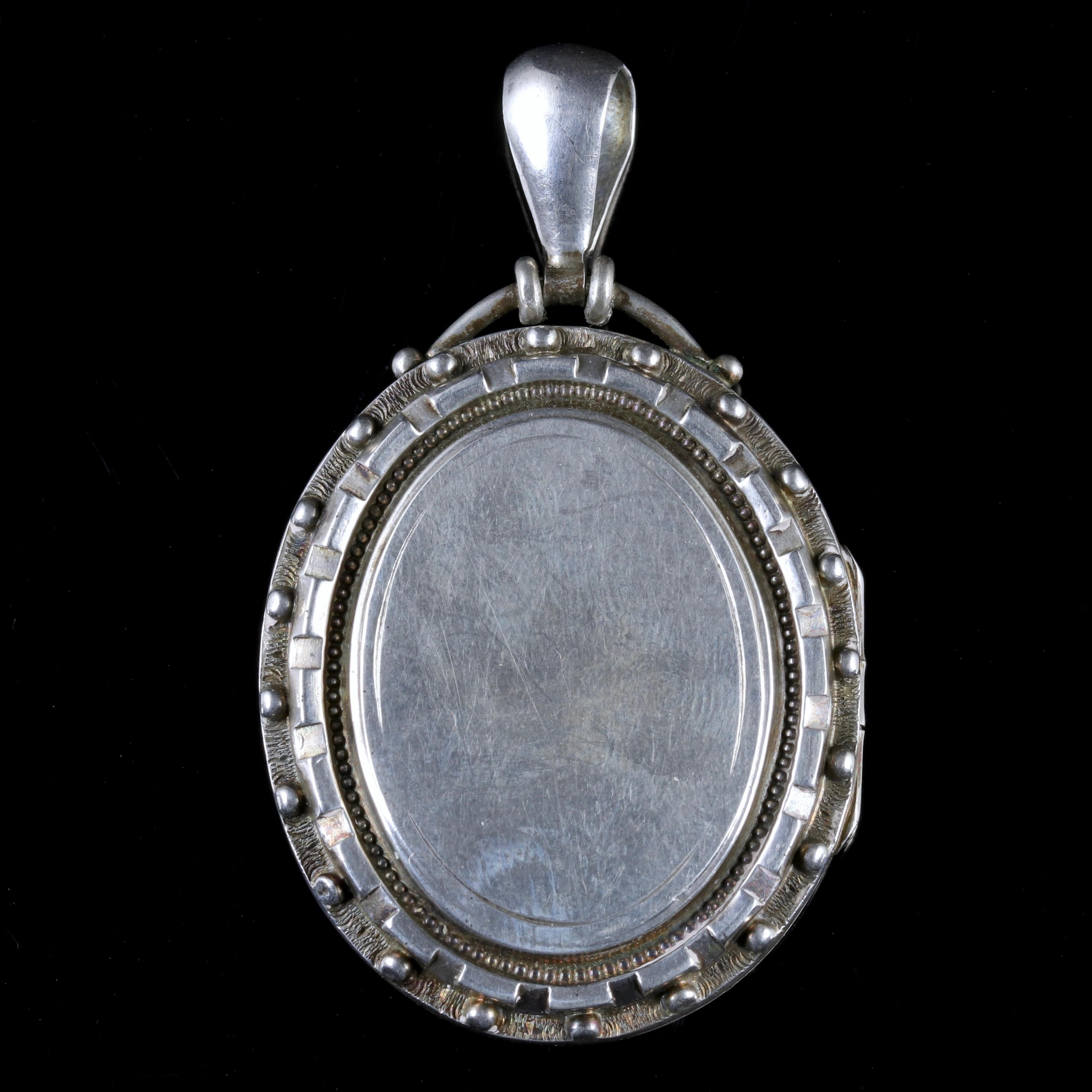 This fabulous Victorian locket is set in Sterling Silver, Circa 1880.

It boasts engraved bobble work all round the locket.

The locket opens to hold two photographs inside, and opens and shuts securely.

Inside, their is a colour painting of a