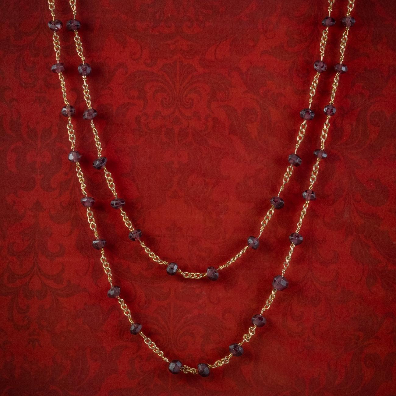 A magnificent antique Victorian guard chain from the late 19th Century decorated with faceted almandine garnet beads with a luxurious, deep violet/ red hue, connected by 9ct gold curb links and held by a ring clasp at the end. 

Guard chains were at