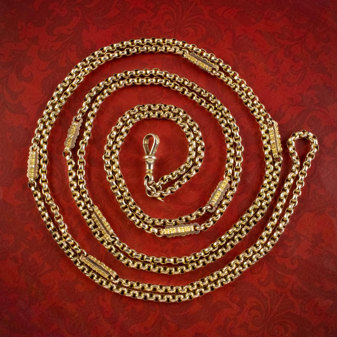 A grand antique Victorian guard chain from the late 19th Century made up of faceted cable links and fancy, interlocked links with jagged edges which lead to the claw clasp at the bottom. It’s all modelled in a bright 9ct yellow gold and has