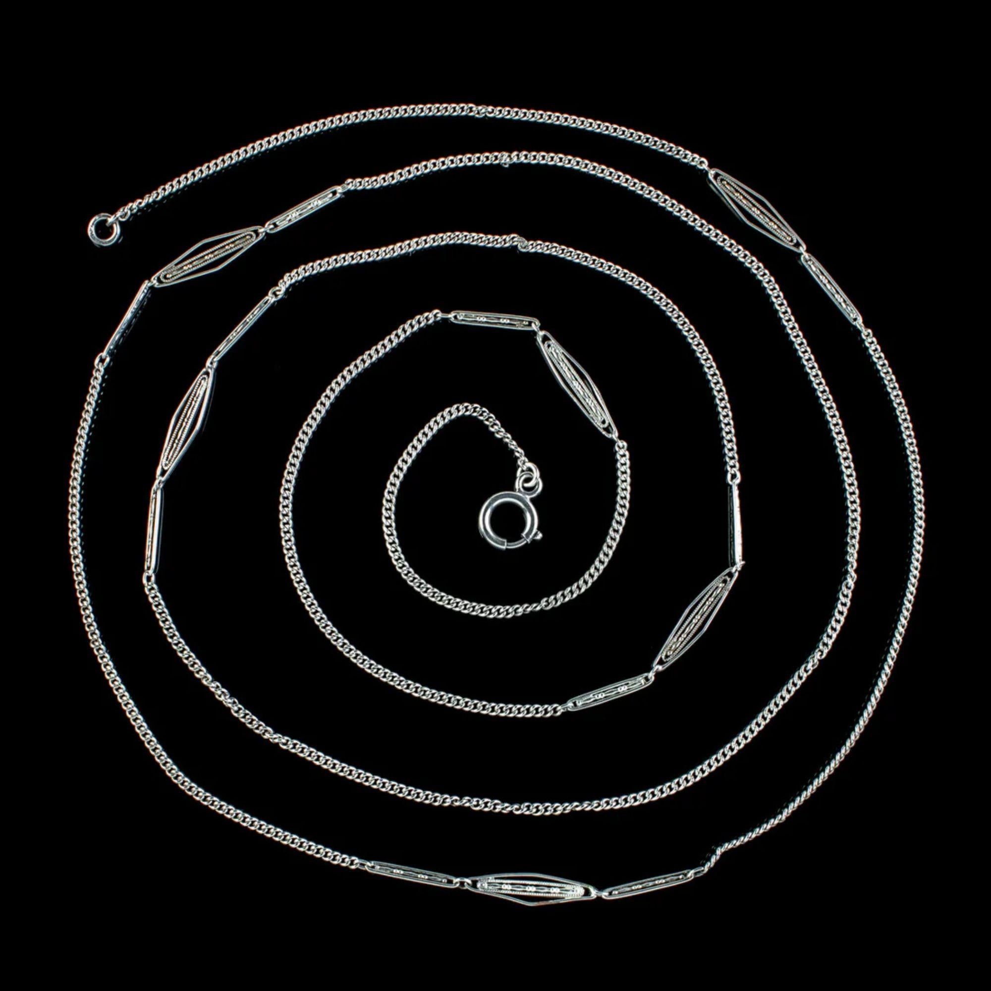 A stylish antique chain made by Mürrle Bennett & Co at the turn of the 20th Century. The silky chain consists of fine silver curb links with larger, open-work links along the length with decorative milgrain detailing.

Mürrle Bennett & Co was