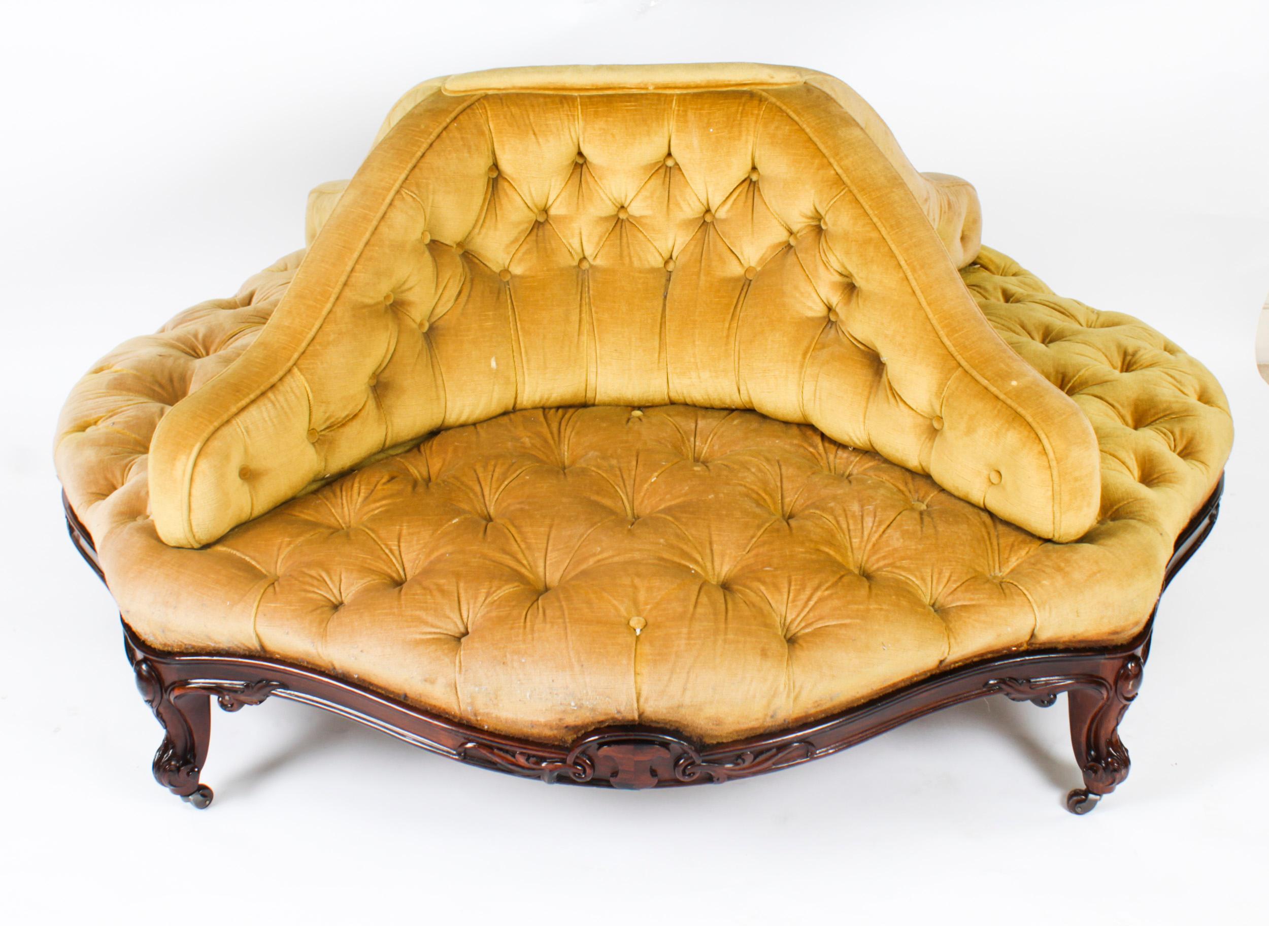 This is a fantastic English antique Victorian walnut framed conversation seat, also known as a 