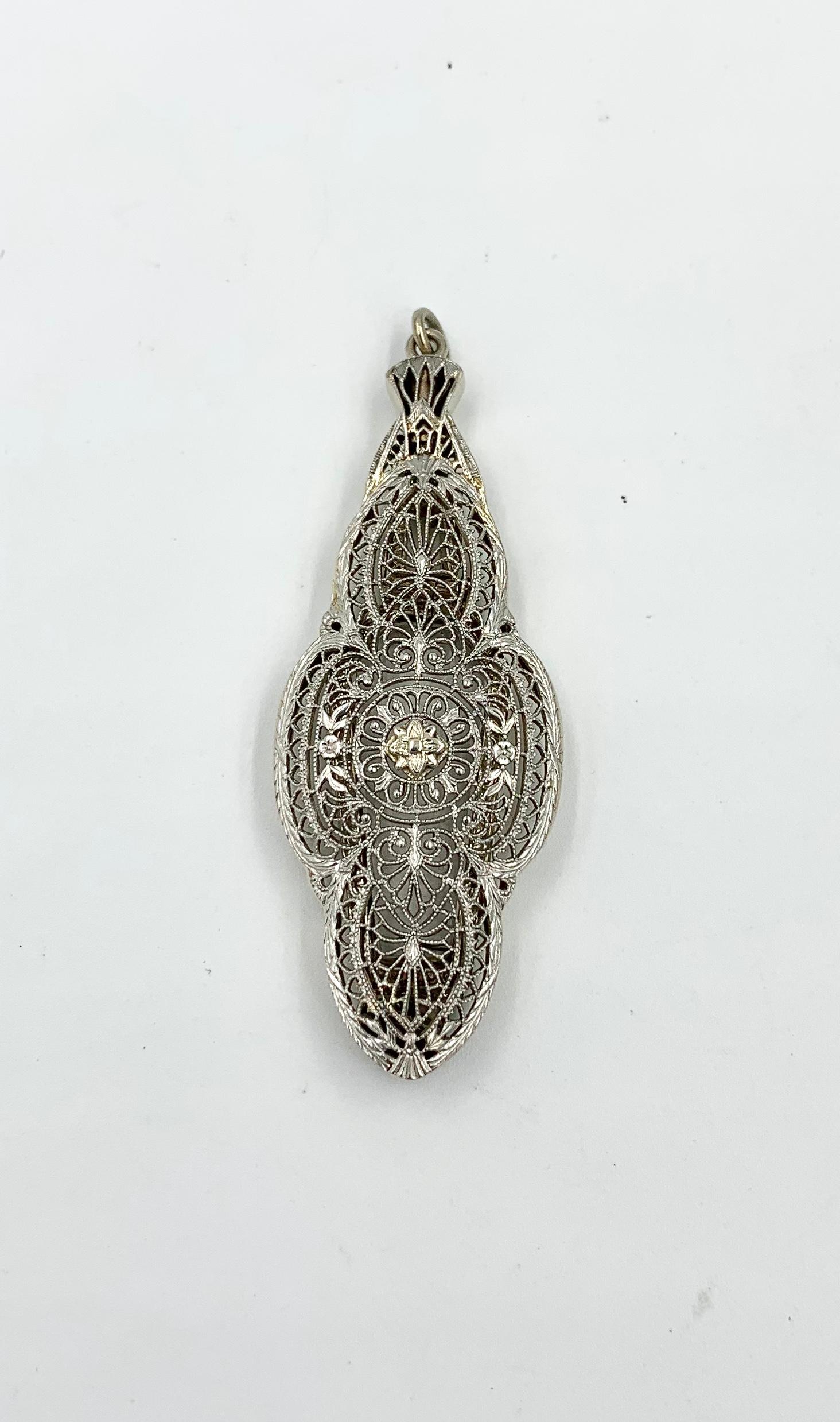 A stunning antique Victorian - Edwardian Magnifying Glass Pendant in 14 Karat White Gold.  A very rare jewel!  The beautiful pendant has stunning open work filigree design of great beauty.   The back of the pendant flips open to reveal a pair of