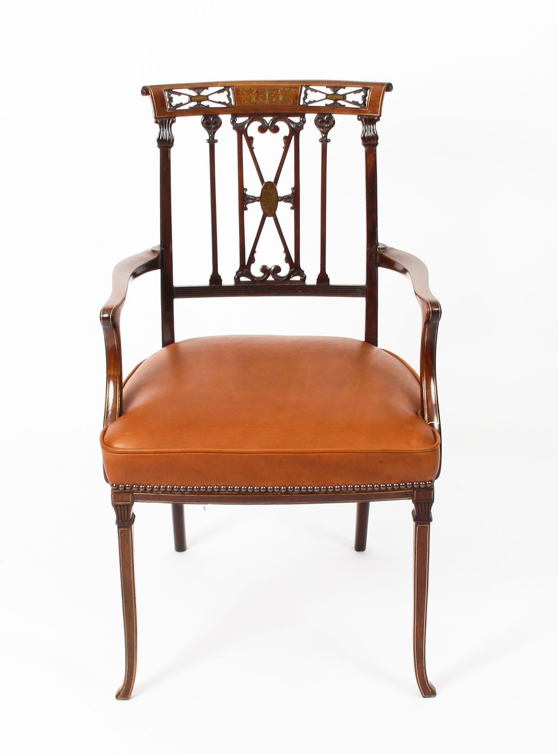This is a beautiful late Victorian antique mahogany brass and boxwood inlaid open armchair, circa 1880 in date.

The scroll top rail has been centred with a stunning brass inlaid panel flanked by a pair of pierced foliate panels. It has a scroll