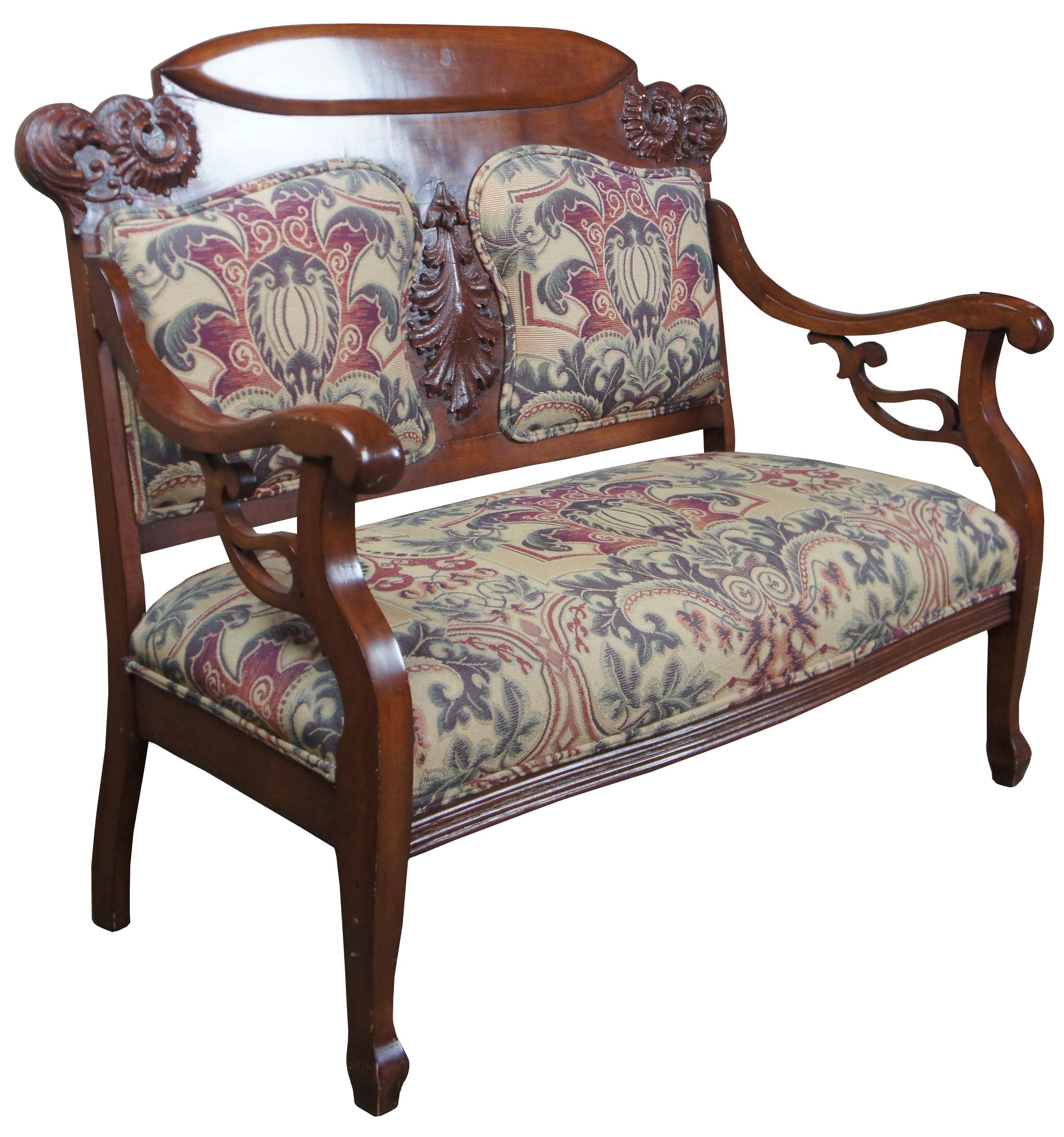 Mid-late 19th century Victorian settee. Made from mahogany with ornate carved back. Featuring split back upholstered panel and seat. Measure: 50