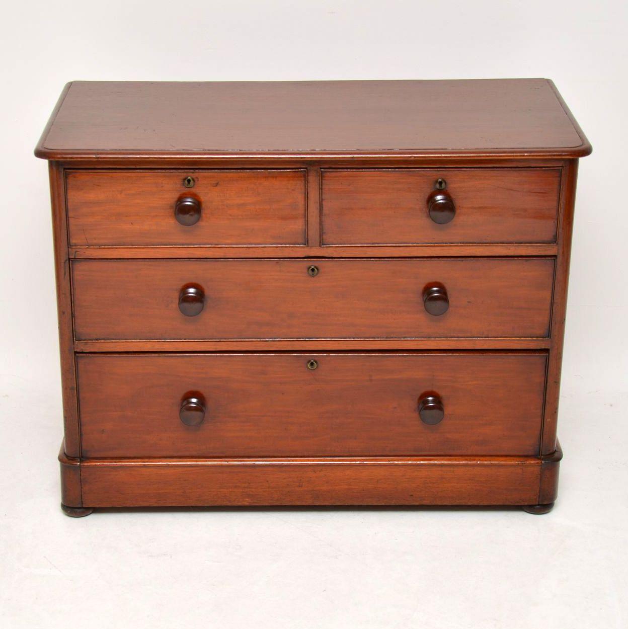 This antique Victorian mahogany chest of drawers has nice proportions, being a bit lower & wider than most. It has a solid mahogany top, original mahogany bun handles & sits on a plinth base with flat bun feet below. The locks & escutcheons are good