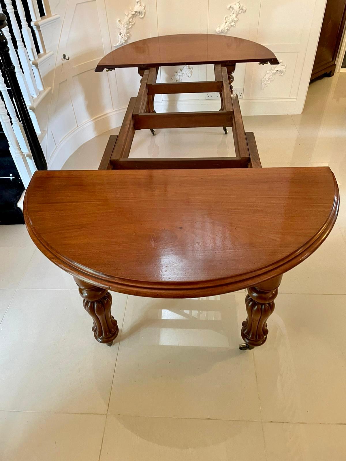 Antique Victorian mahogany extending dining table having a quality mahogany round top with a double moulded edge, three extra leaves extending to make a D end shaped dining table. It stands on shaped fluted reeded legs with original cup