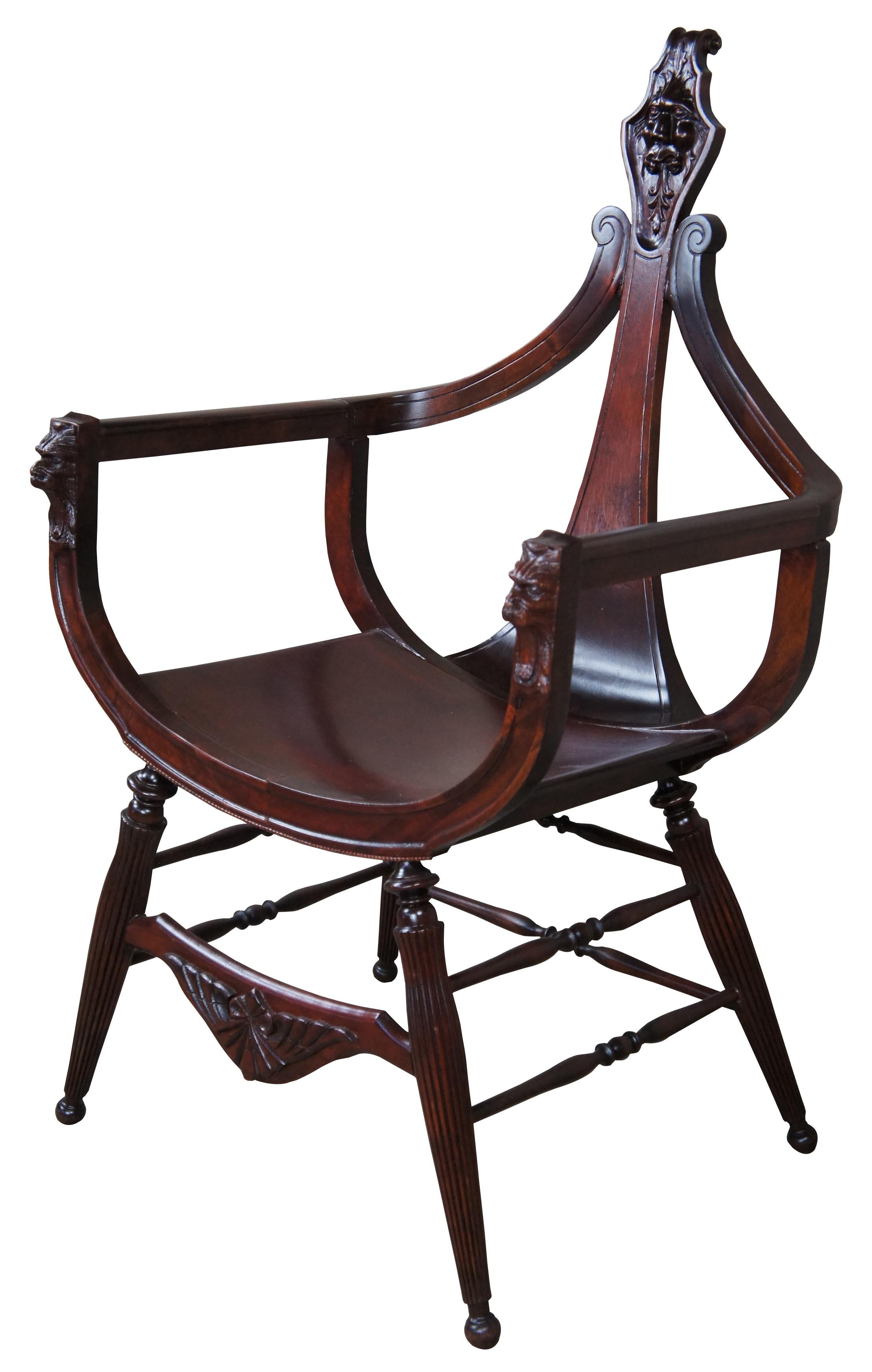 A late 19th century antique Victorian occasional arm chair. Made from mahogany with a curule or saddle seat form and lion head carvings. Features a cello neck back tapering to a scrolled crest. The seat is supported by turned reeded legs. 
 