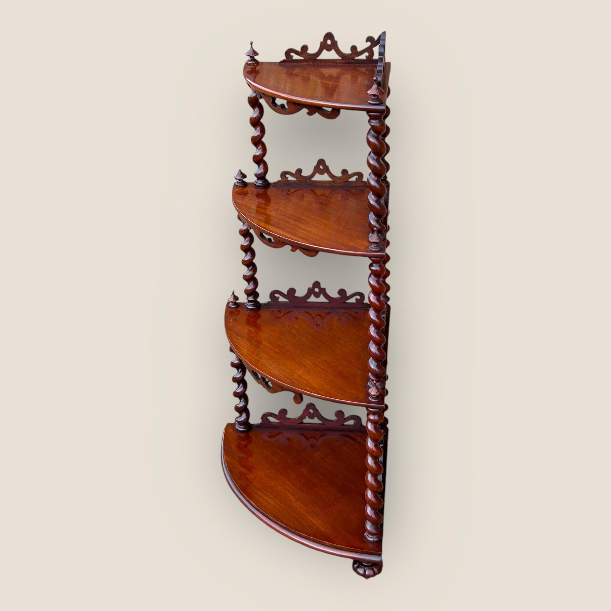 Nous avons ici ce magnifique meuble victorien à quatre niveaux en acajou avec des colonnes torsadées et des côtés décoratifs sculptés. Pieds godronnés, roulettes à chaque niveau et deux flèches en acajou sculpté à chaque niveau, dont l'une est