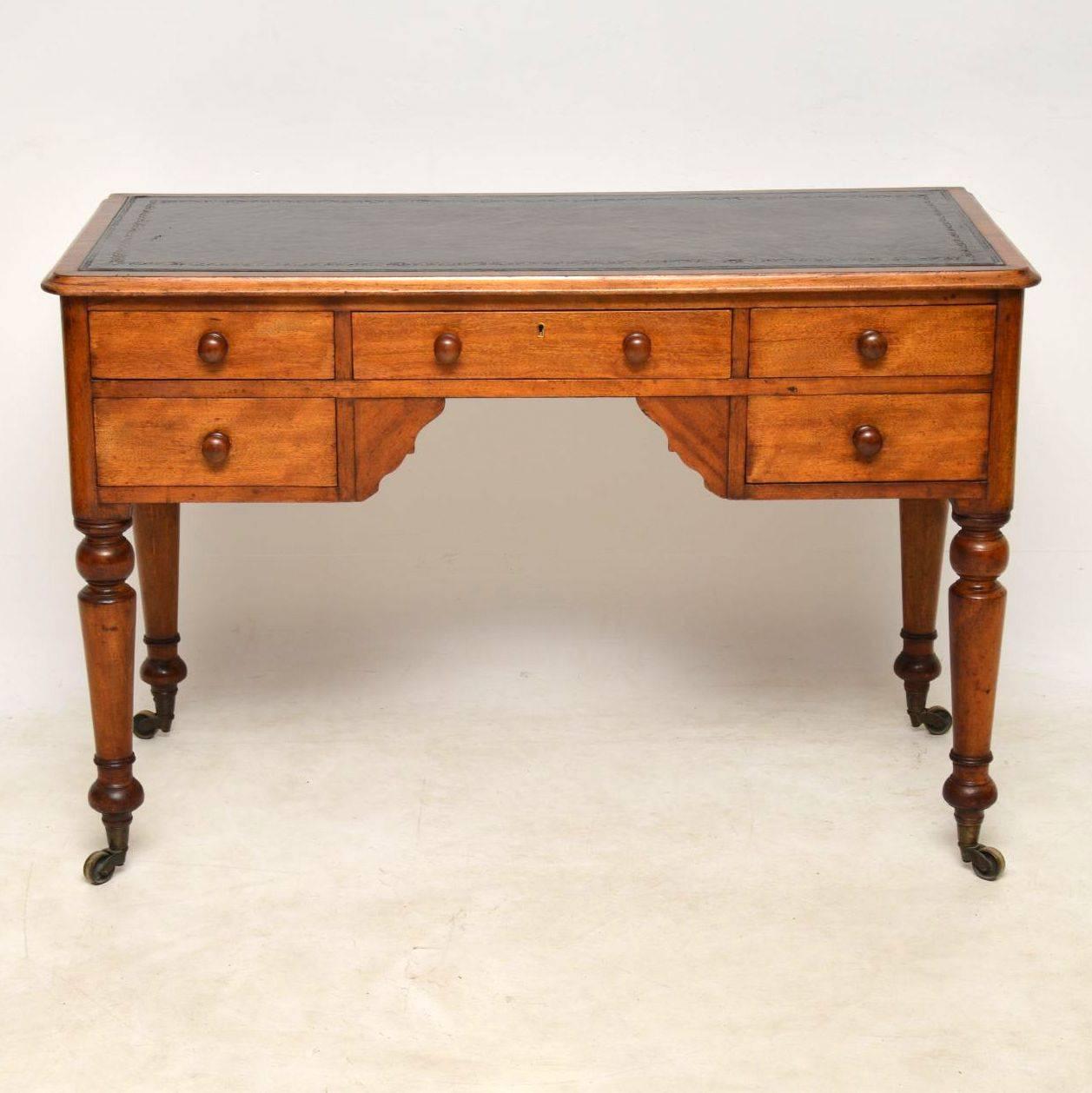 Antique Victorian Satin Birch leather top desk in good original condition, with plenty of character and with a lovely mellow color. It has a tooled leather writing surface, a polished back, well turned legs and original brass casters. The drawers