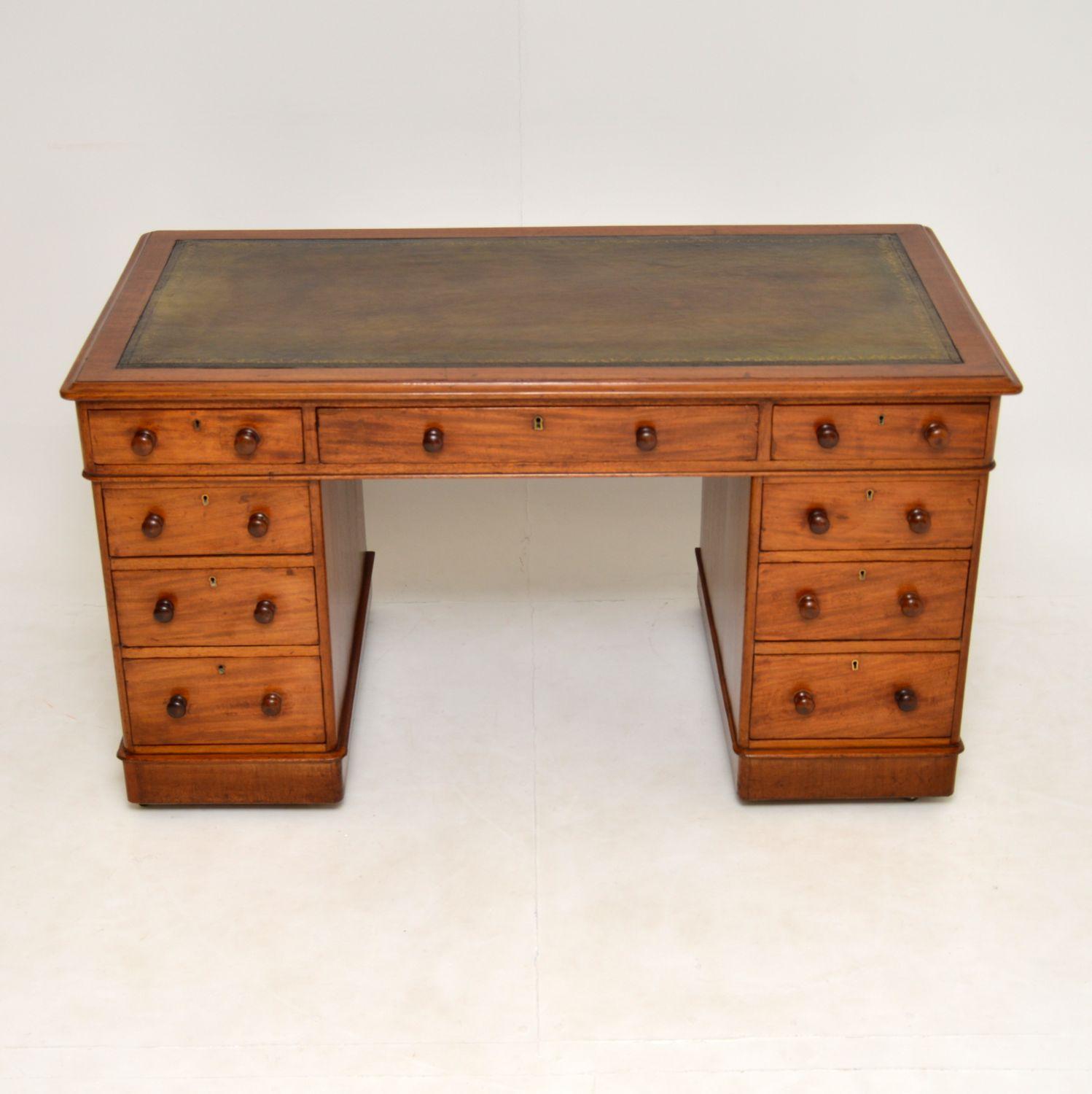 An excellent antique Victorian period pedestal desk in mahogany. This dates from around 1860-1880.

It is very well made, with an inset leather top, lovely turned handles and a plinth base on brass casters. The drawers which are graduated in