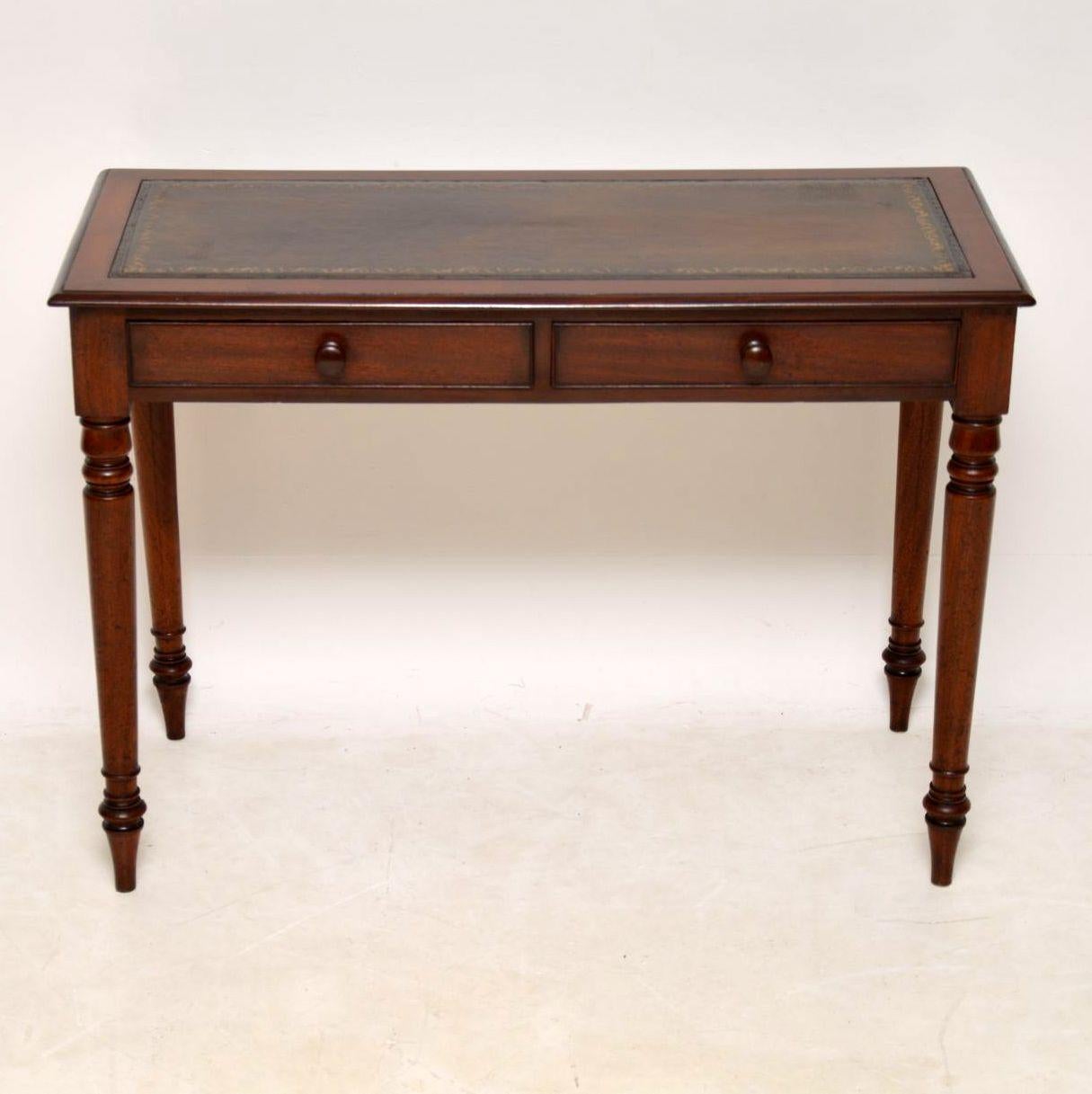 Antique Victorian mahogany writing table in excellent condition, with a tooled leather writing surface. It has two drawers with fine dovetails, mahogany handles and sits on turned legs. This desk has a good original color and is full of character. I