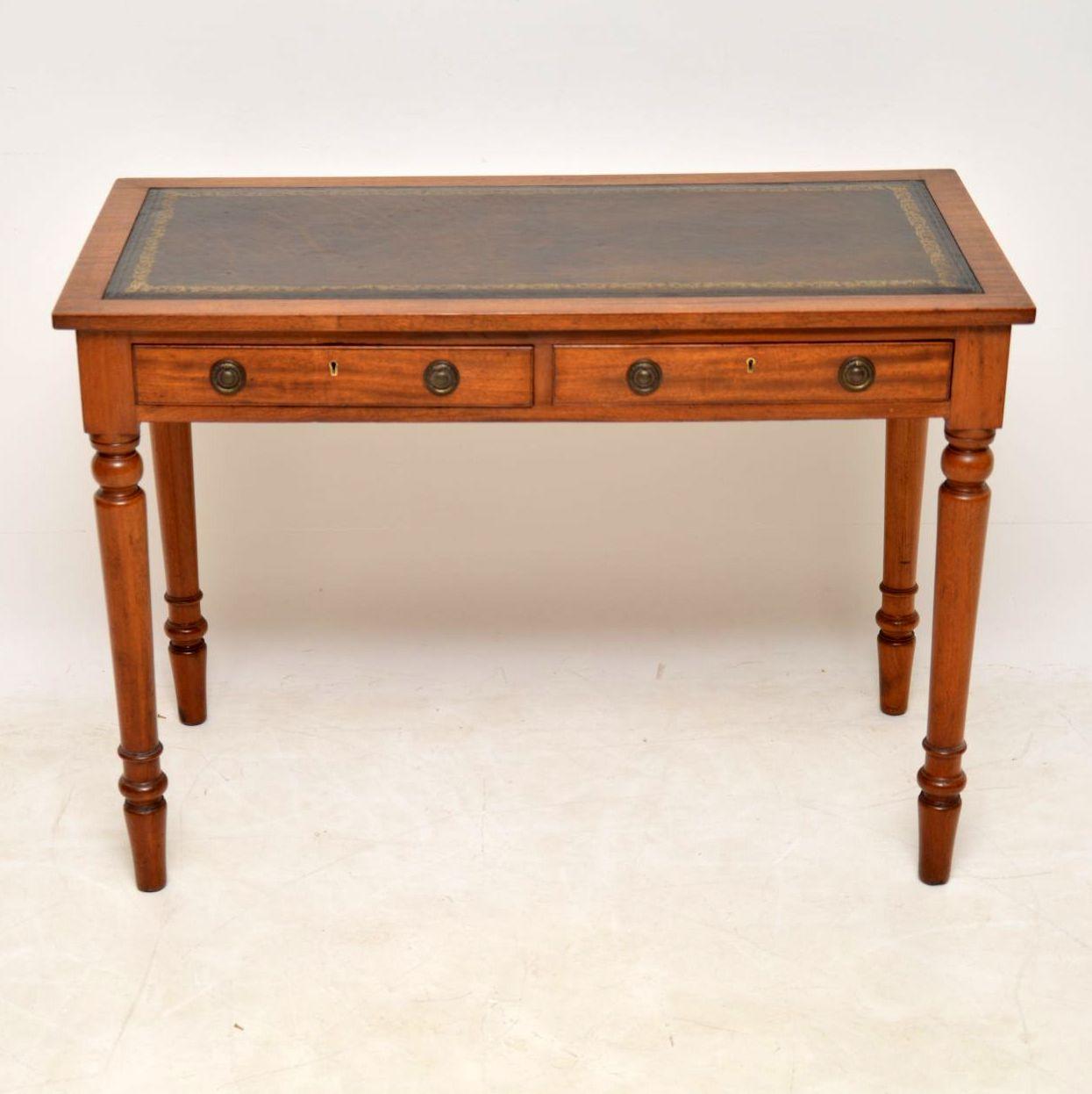 Antique Victorian mahogany leather top writing table in good condition and dating to circa 1860s-1880s period. This desk is fine quality. It has a tooled leather writing surface, a polished back, two drawers with brass handles and sits on strong