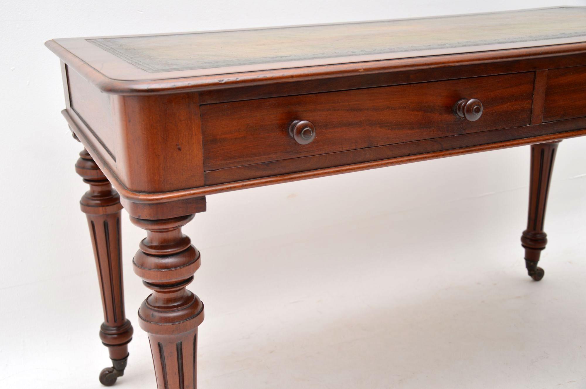 This large antique early Victorian writing table is superb quality and a fine looking piece of furniture. It has a hand coloured tooled leather writing surface and a polished back. There are two drawers with original turned handles and fine