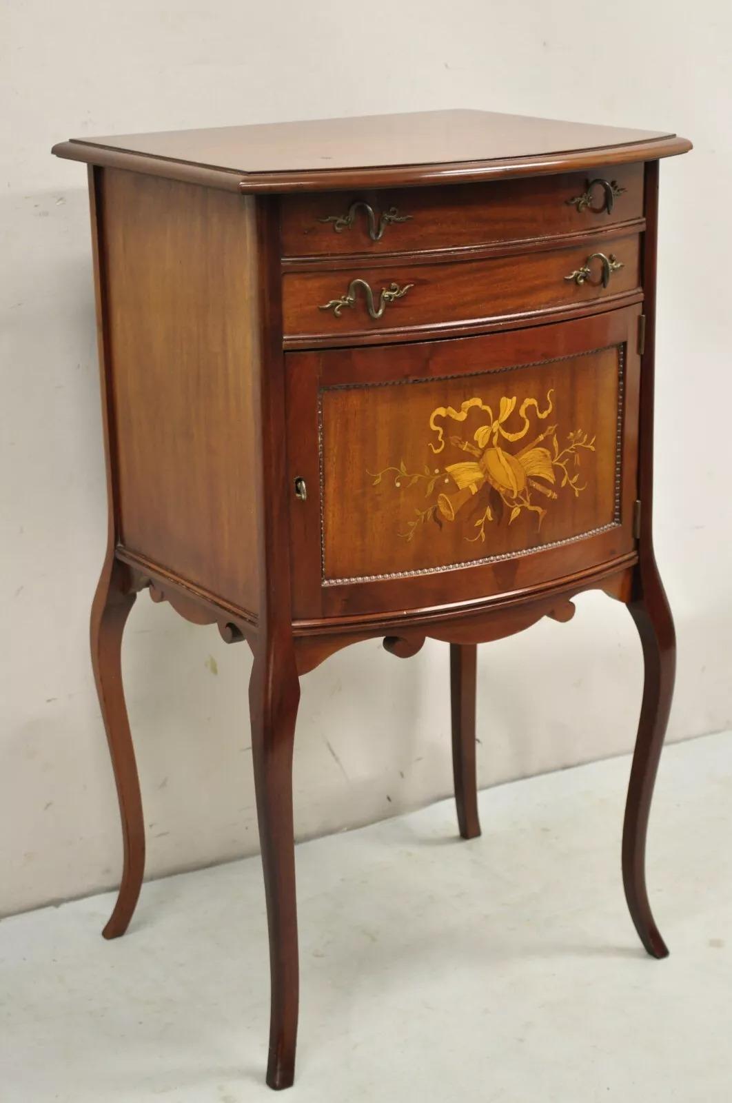 Antigua mesa auxiliar victoriana de caoba con tapa elevable y marquetería. El artículo tiene una sola puerta batiente, parte superior elevable, incrustaciones de instrumentos musicales, herrajes de latón, patas cabriolé, cerradura y llave que
