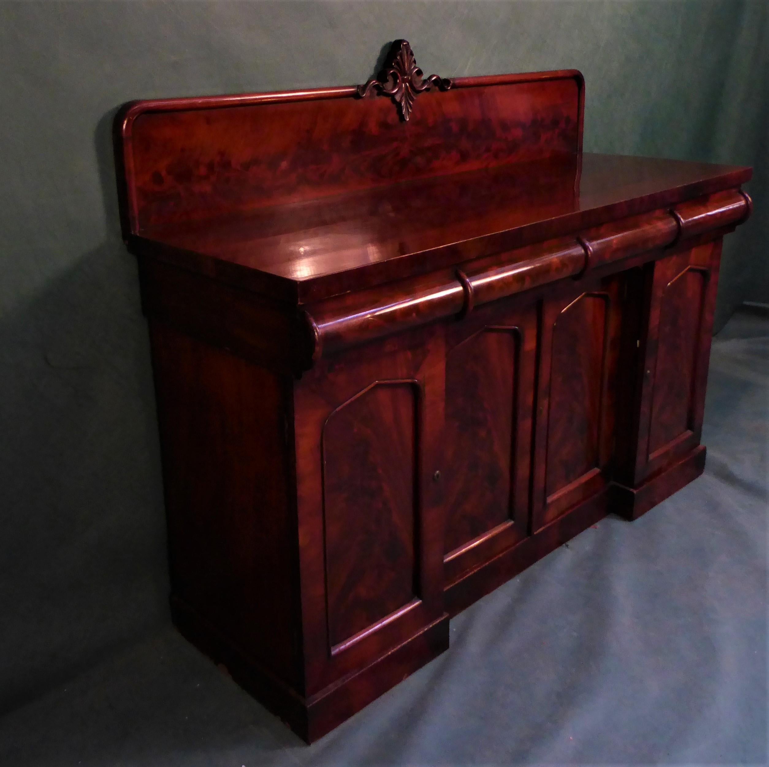 Antique Victorian mahogany sideboard of beautiful, simple and useful shape. 
There are three drawers in frieze with barrel front, beneath which is a central cupboard double door containing one shelf franked on each side with another cupboard, one