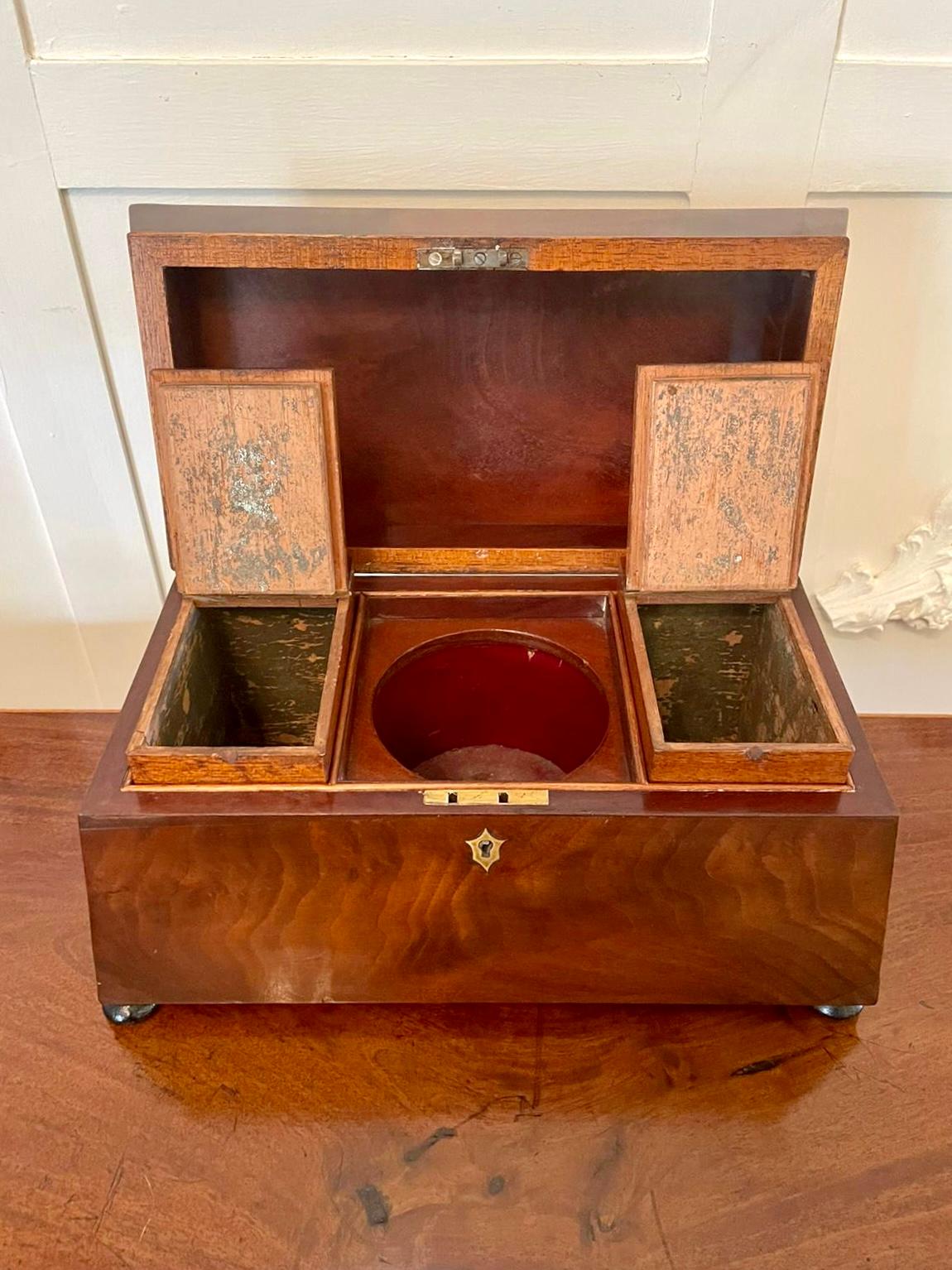 Antique Victorian mahogany tea caddy having a shaped figured mahogany lift up top opening to reveal a fitted interior with three compartments, two having original lift out tops. The front and sides are figured mahogany. It is raised on original