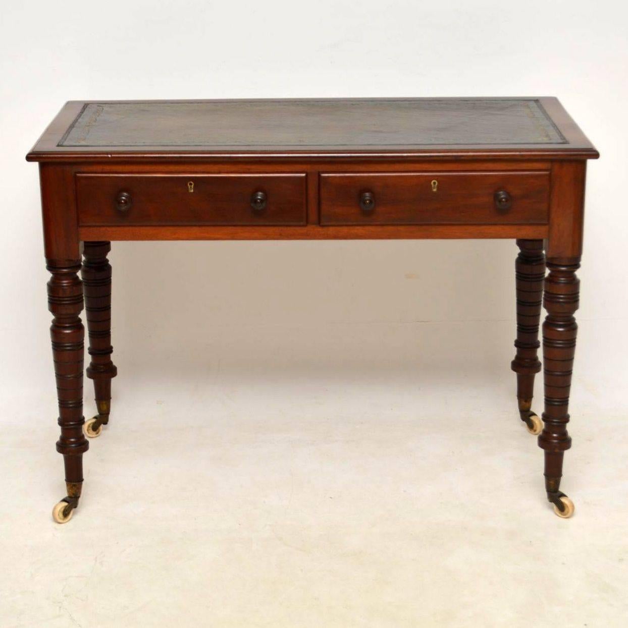 Antique Victorian mahogany leather top writing table desk in good condition. It has a tooled leather writing surface, two drawers on the front with turned wooden handles and locks, plus the back is polished too. The legs have a multitude of turnings