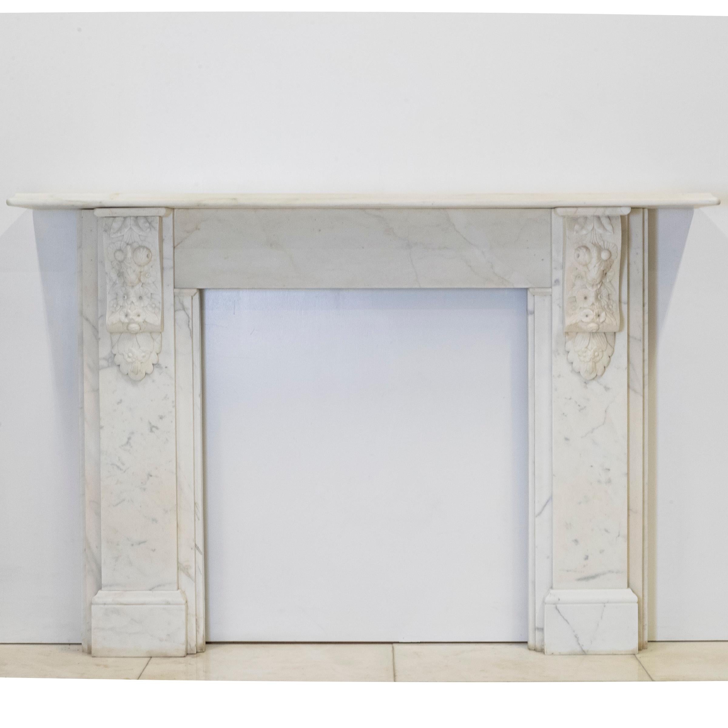 A Fine Antique Carved Marble Fireplace Surround with Carved Corbels

An exceptional example of 19th-century craftsmanship, this antique fireplace surround is executed in Carrara marble. Its restrained, classical form is distinguished by a pair of