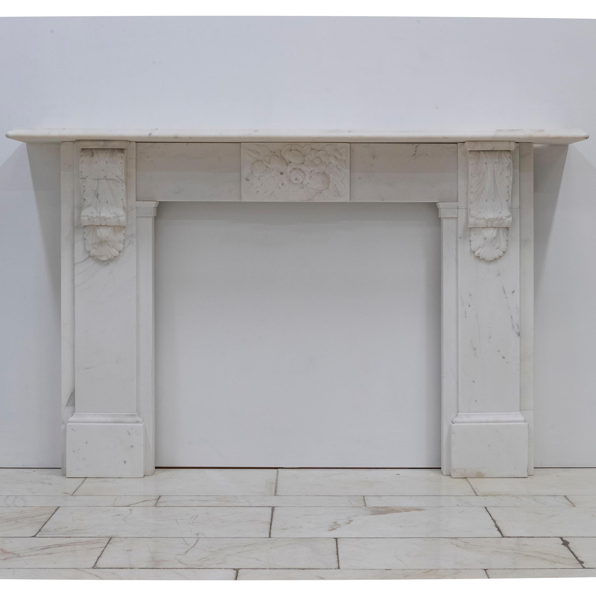 Presenting an exceptional Victorian marble fireplace, expertly carved from Carrara marble.

Poised to serve as a distinguished focal point, this chimneypiece has substantial corbels sculpted in a classical acanthus-leaf motif, and the central frieze