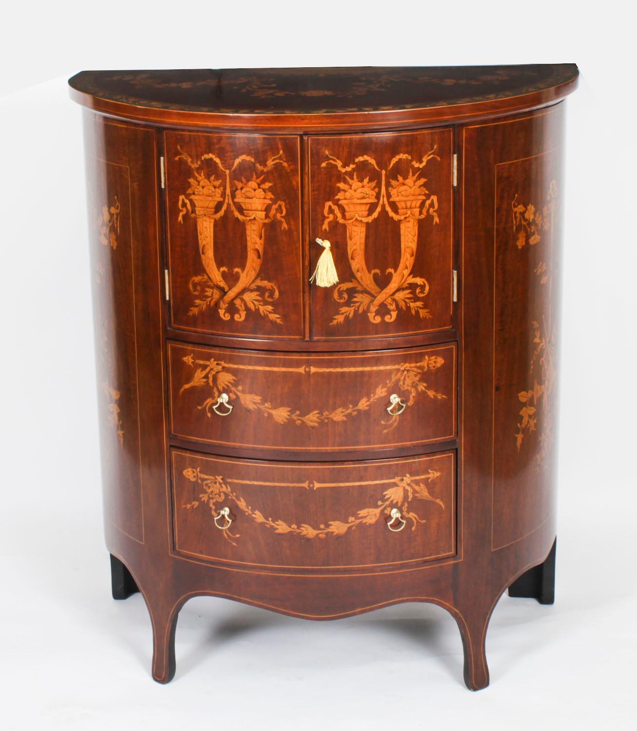 Si tratta di un elegante mobile inglese antico vittoriano intarsiato in demi-lune, datato circa 1880.

Questo splendido mobile è realizzato in mogano a fiamma e presenta un bellissimo intarsio di linee di legno satinato con decorazioni a intarsio